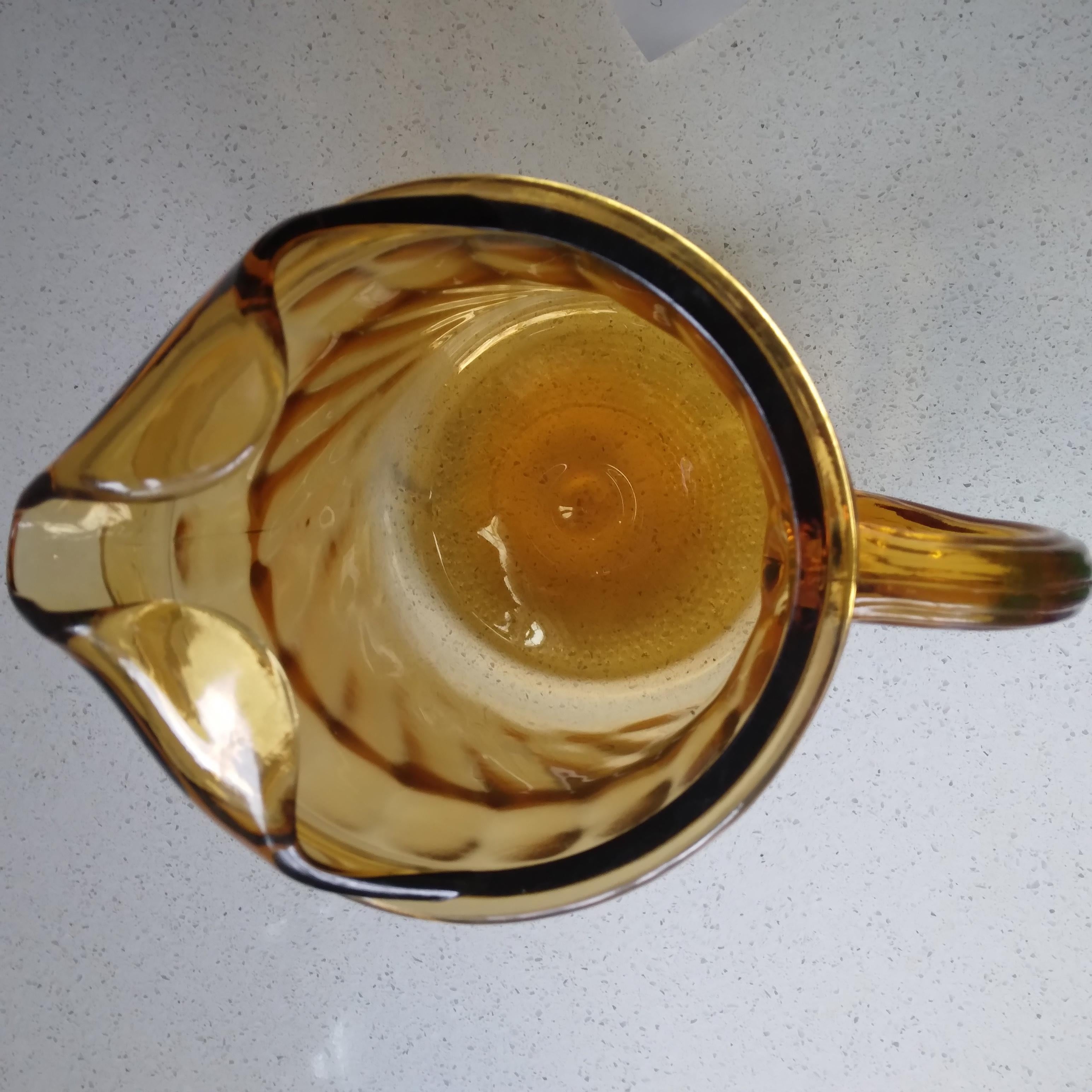 Adorably vintage, we love the rich amber color of this glass pitcher. The smooth swirl pattern of the glass is pretty but not distracting. Perfect for summer drinks with the convenient ice lip at the rim.

The thick walled glass is in excellent
