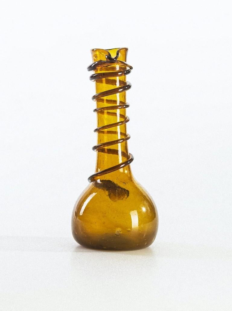 Die Vintage-Vase aus Braunglas ist ein wunderschönes Dekorationsobjekt aus Glas, das in den 1970er Jahren hergestellt wurde.

Sehr modische, bernsteinfarbene, transparente Vase mit mundgeblasenem Glasdekor am Hals.

Gute Bedingungen.