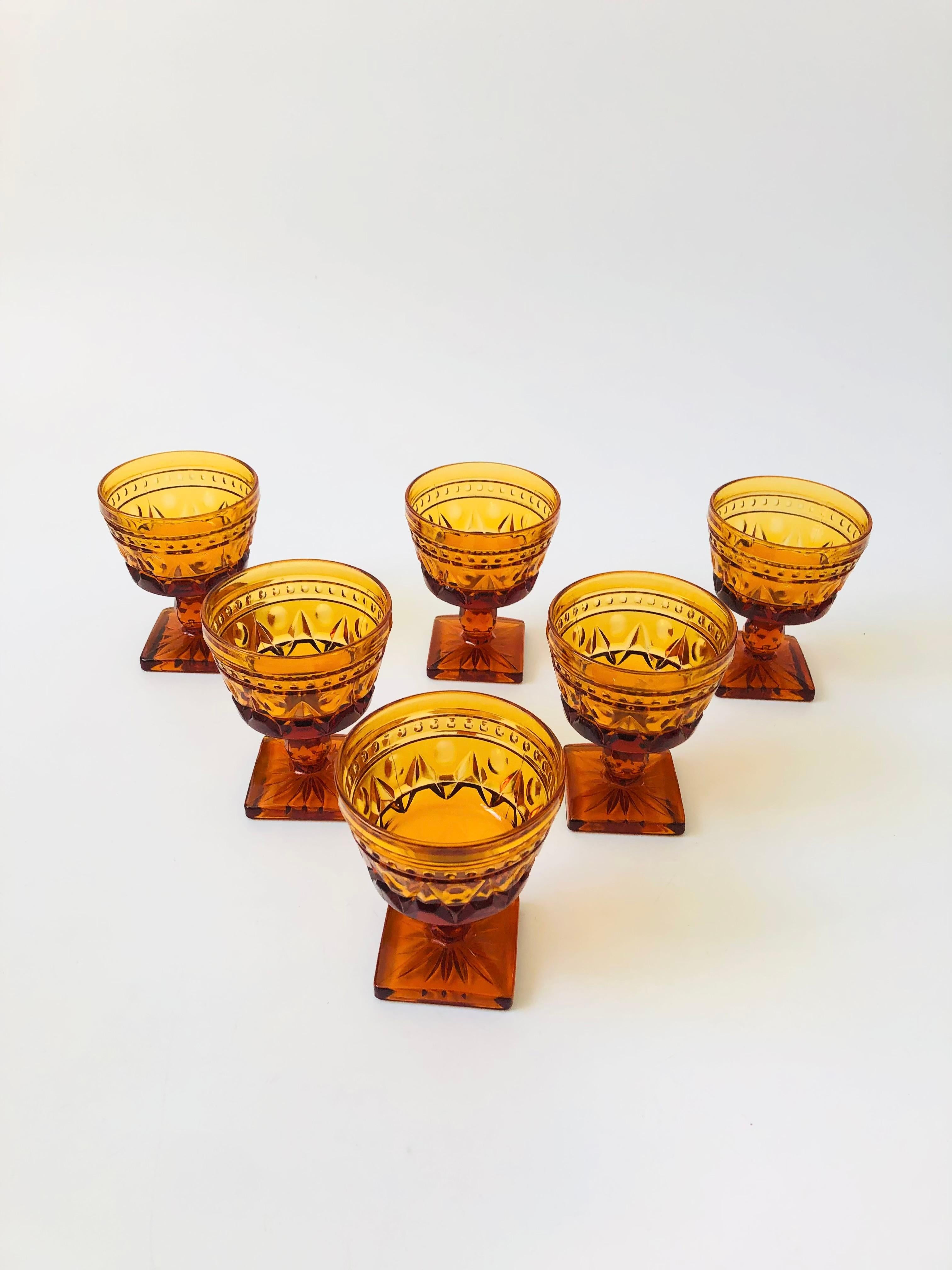 A set of 6 gorgeous coupe glasses with a lovely ornate design in amber glass. Made in the 