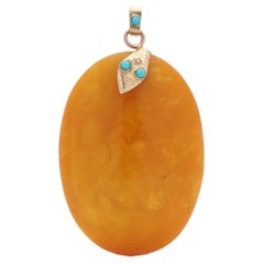 Vintage Amber pendant with 9kt. rose gold mount in the shape of a serpent's head