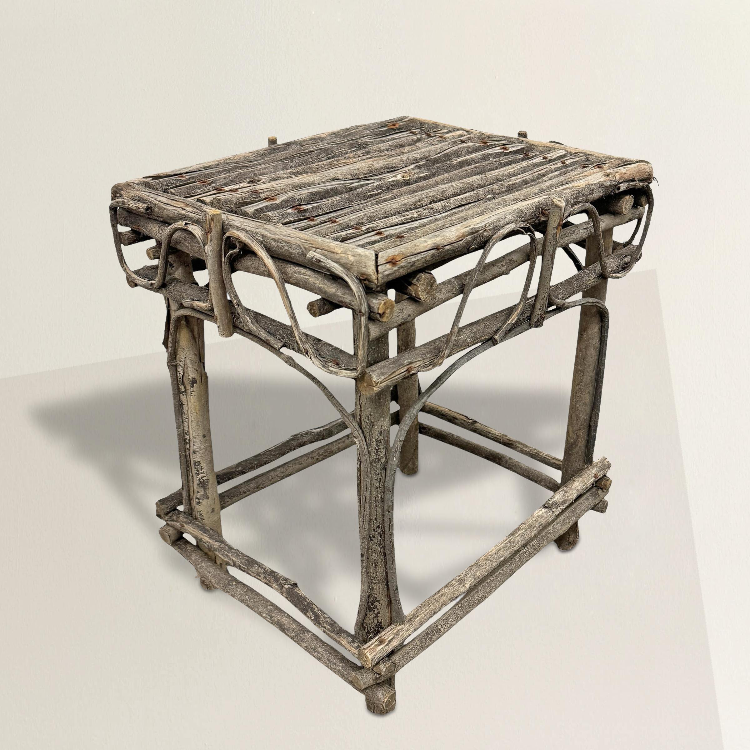 This vintage American Adirondack twig table captures the rustic elegance and artisanal craftsmanship that define Adirondack design. Its bentwood apron forms a graceful, rhythmic pattern, a hallmark of the region's design principles, which emphasize