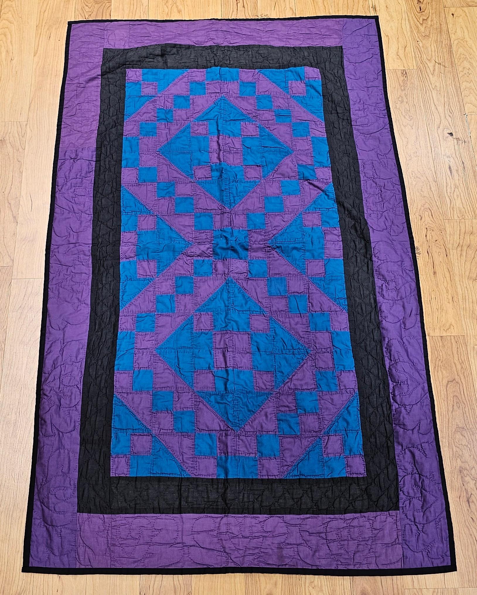  A striking mid-20th century Amish cotton quilt from Lancaster County, Pennsylvania, meticulously hand-stitched in the traditional “Jacob’s Ladder” pattern. This quilt showcases a distinctive palette of purple, green, and teal, with each individual