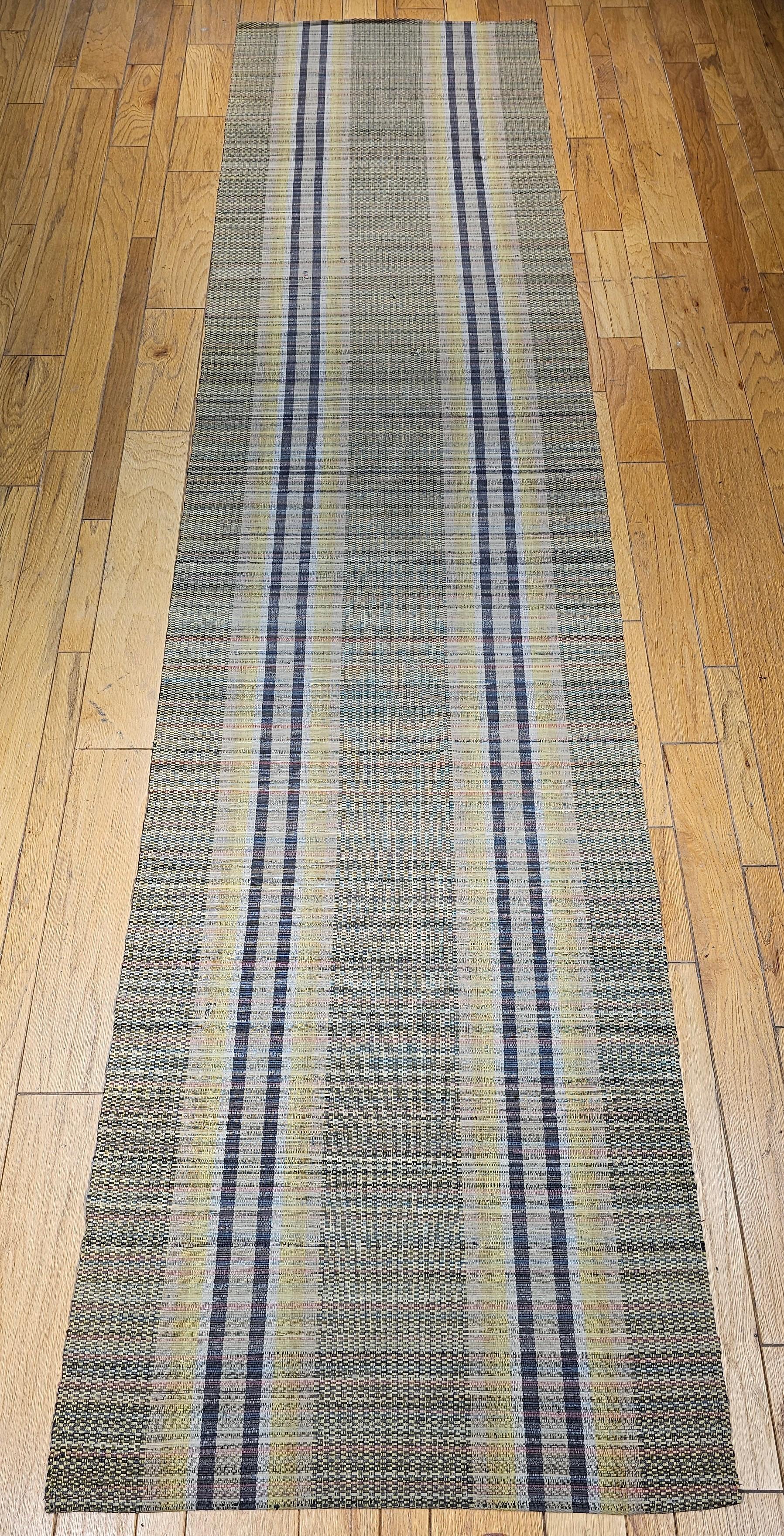 Vintage American Rag Runner from the early 1900s.  This beautiful American rag runner has a long stripe pattern set on a pale green background with accent colors of yellow and blue.  The Amish community in Pennsylvania wove these runners mainly for