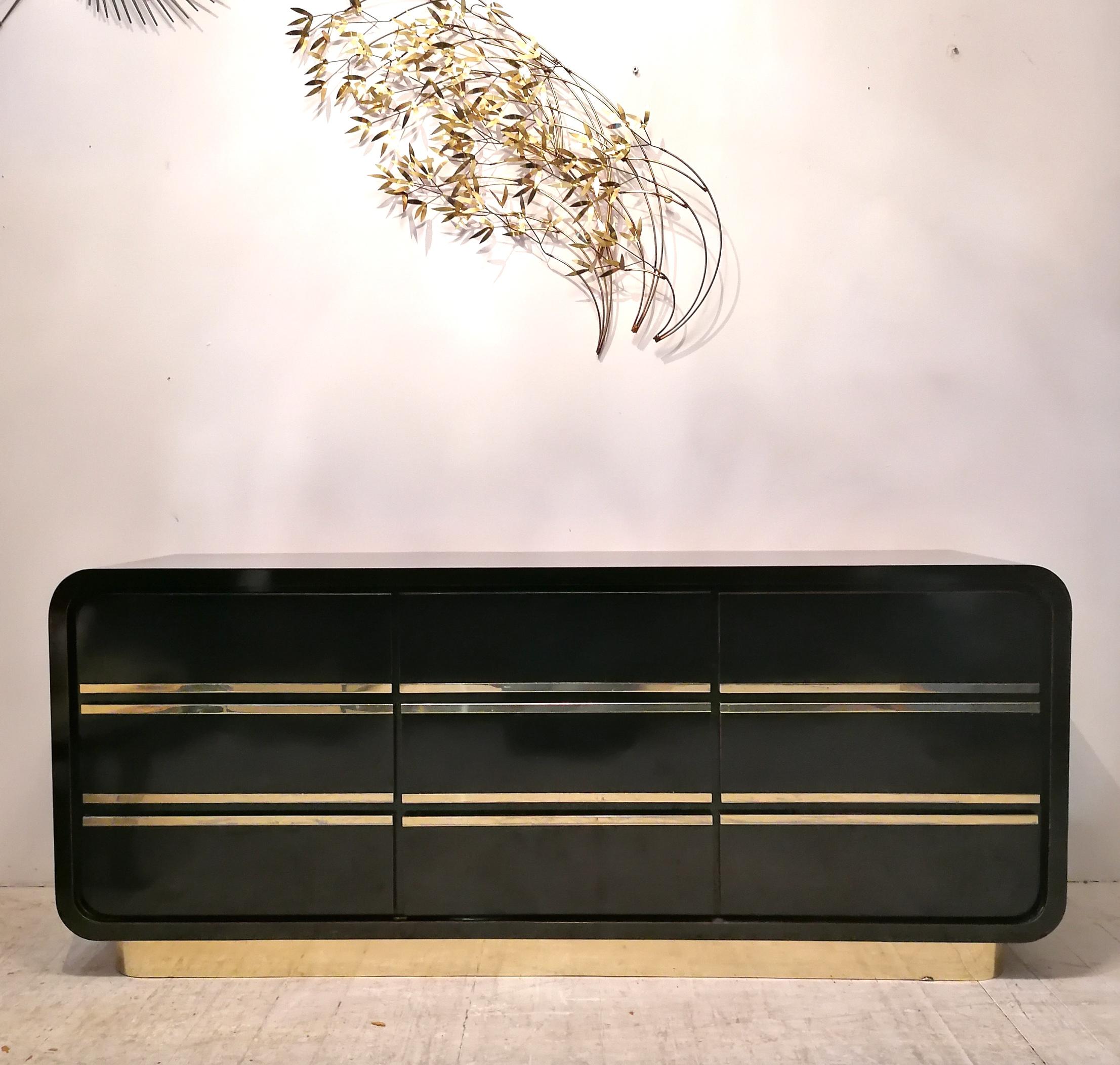 


A stunning deco revival black laminate & gold sideboard with 9 drawers, USA 1980s. Waterfall ends, gold metal plinth base. Good vintage condition: a few very minor repaired chips, a little age-related wear to gold metal.
