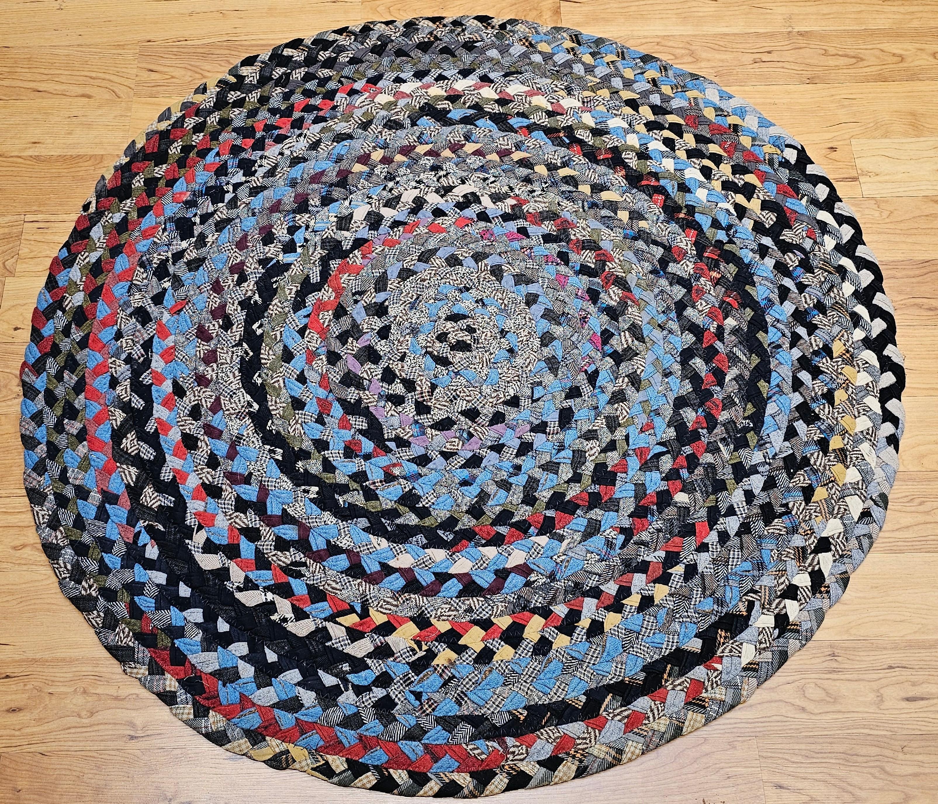 Vintage American Braided Round area rug in blue, red, ivory, green from the 2nd quarter of the 1900s in Red, White, Blue, Yellow, Gray colors.  The rug is a best example of recycling and reusing material as a way of life.  It is made of pieces of