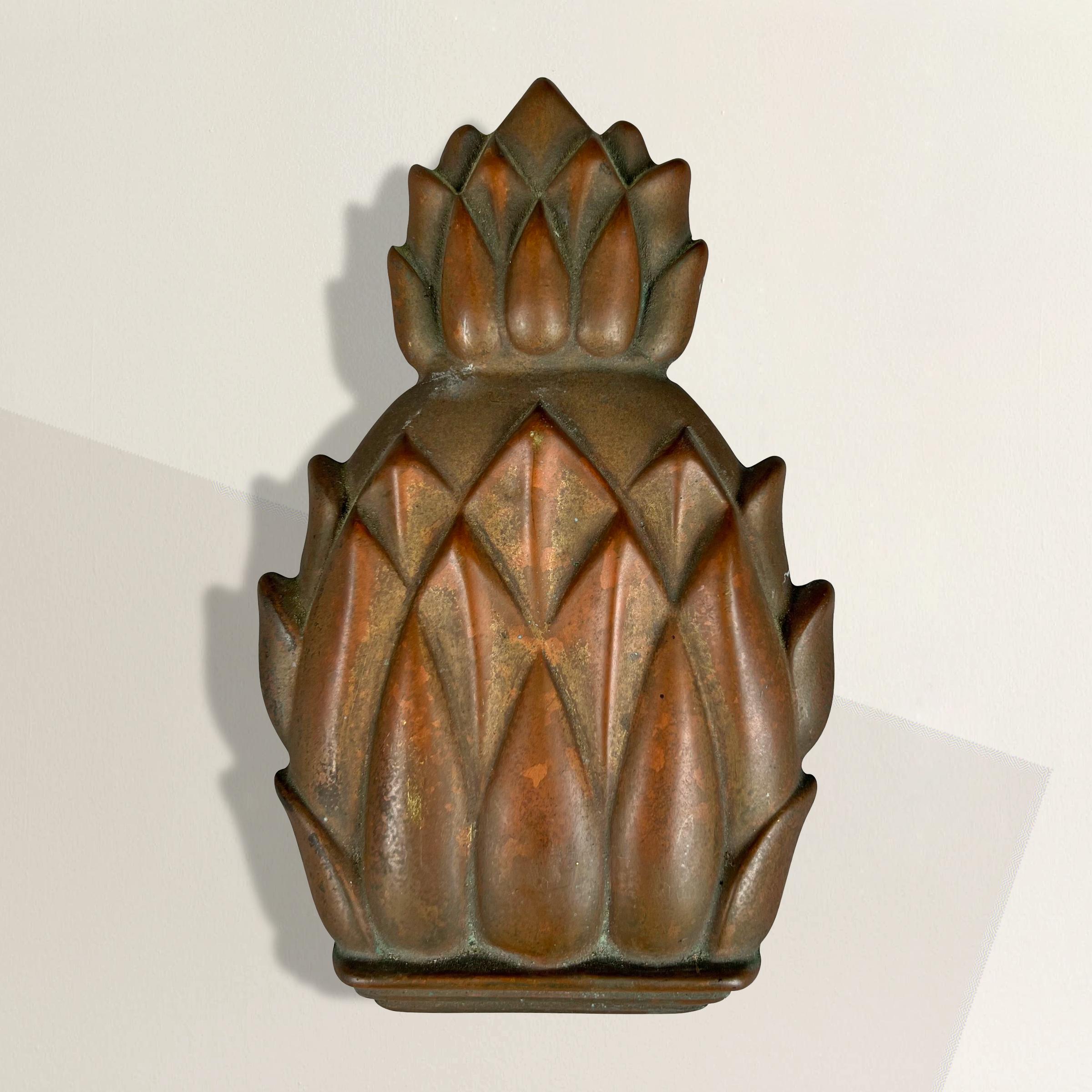 Elevate the entrance to your home with this remarkable mid-20th century American cast brass door knocker, meticulously crafted in the shape of a pineapple. Beyond its stunning aesthetic appeal, the pineapple holds deep symbolism that adds a touch of