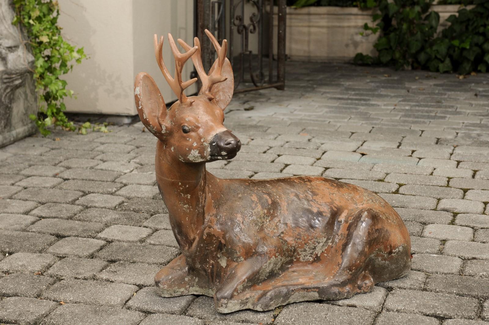 A vintage American concrete deer sculpture with iron antlers and weathered patina. Born during the first half of the 20th century, this deer sculpture charms our eyes with its touching representation. Boasting a nicely worn appearance, the sculpture
