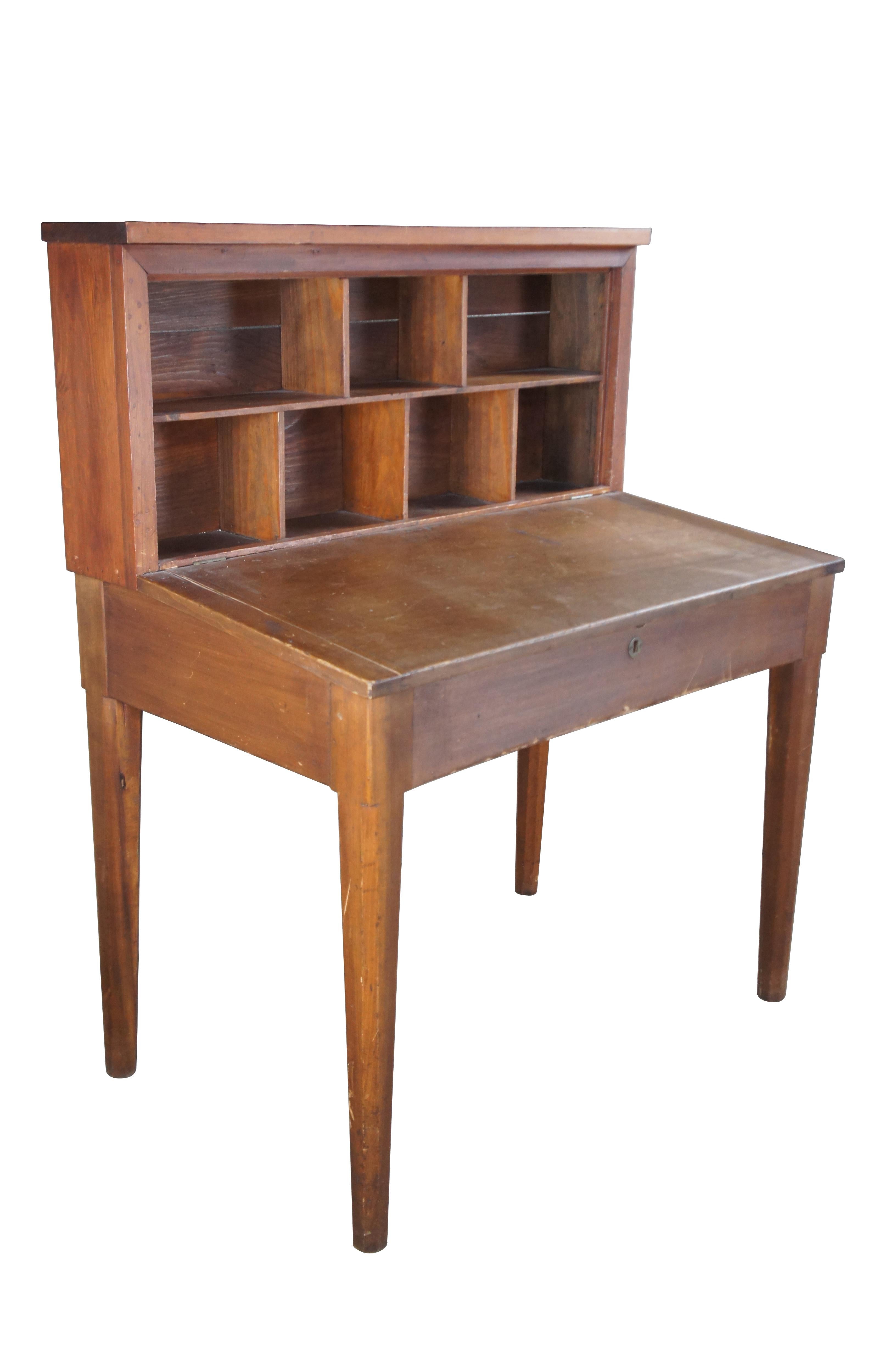 American Pine Clerks Desk, Circa 1930-40s.  Features a hinged and sloped top over chamfered, tapered legs.  The petite hutch along the back is divided into compartments and is perfect for storage of letters or small books.  

Dimensions:
23.5