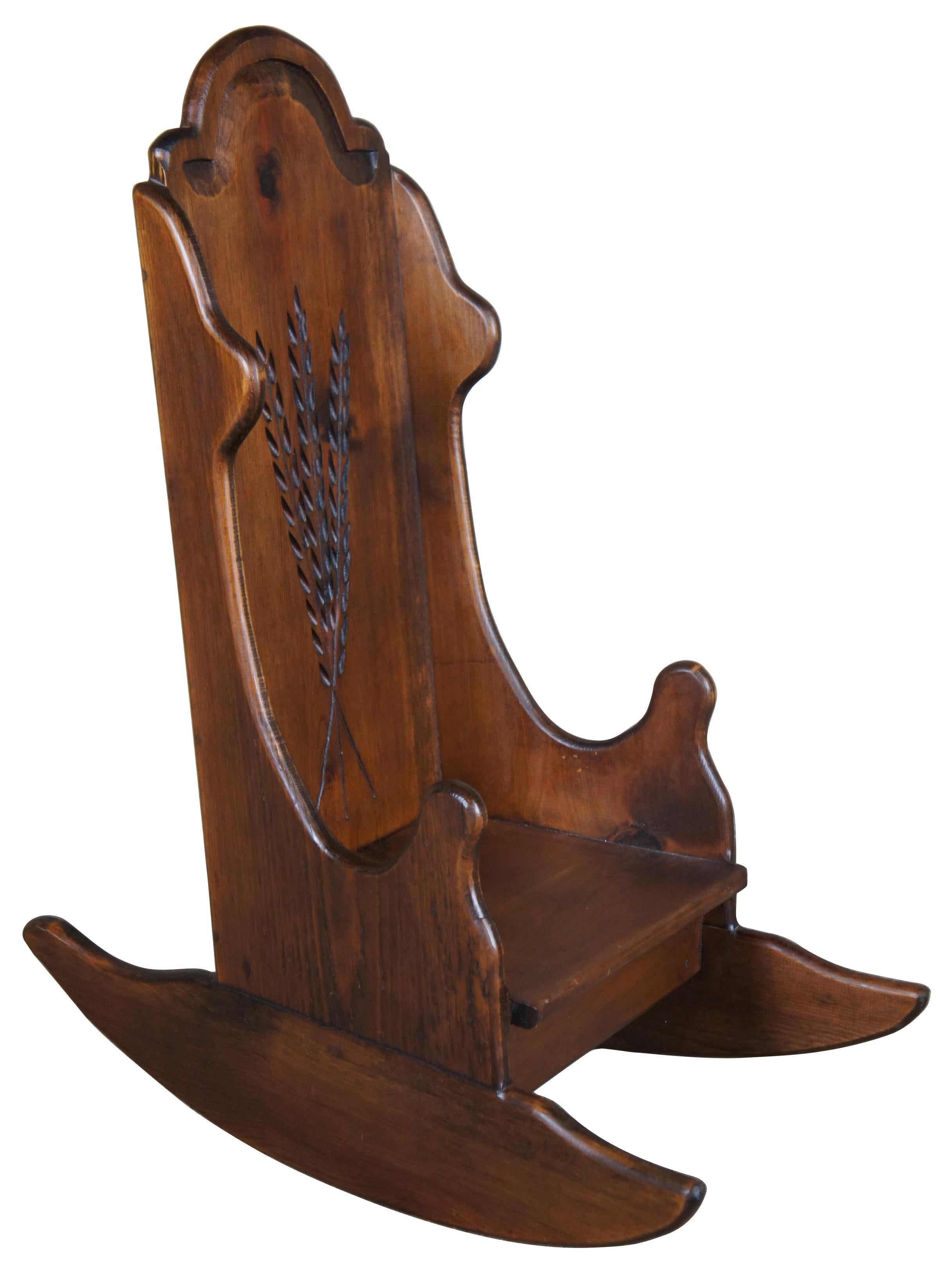 Circa 1970s childs or doll sized rocking chair. Made from pine with sheaf of wheat carved back. 
 