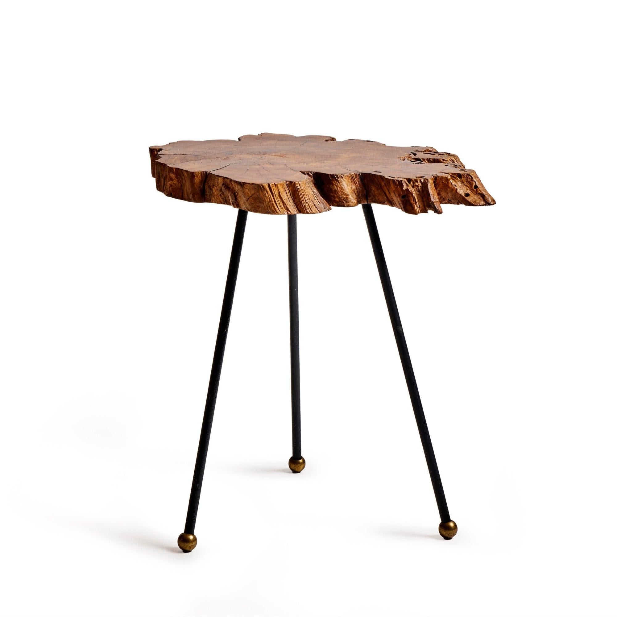A free edge Cypress burl wood side table raised on three wrought iron rod legs with bronze ball tipped feet. American, 1965
