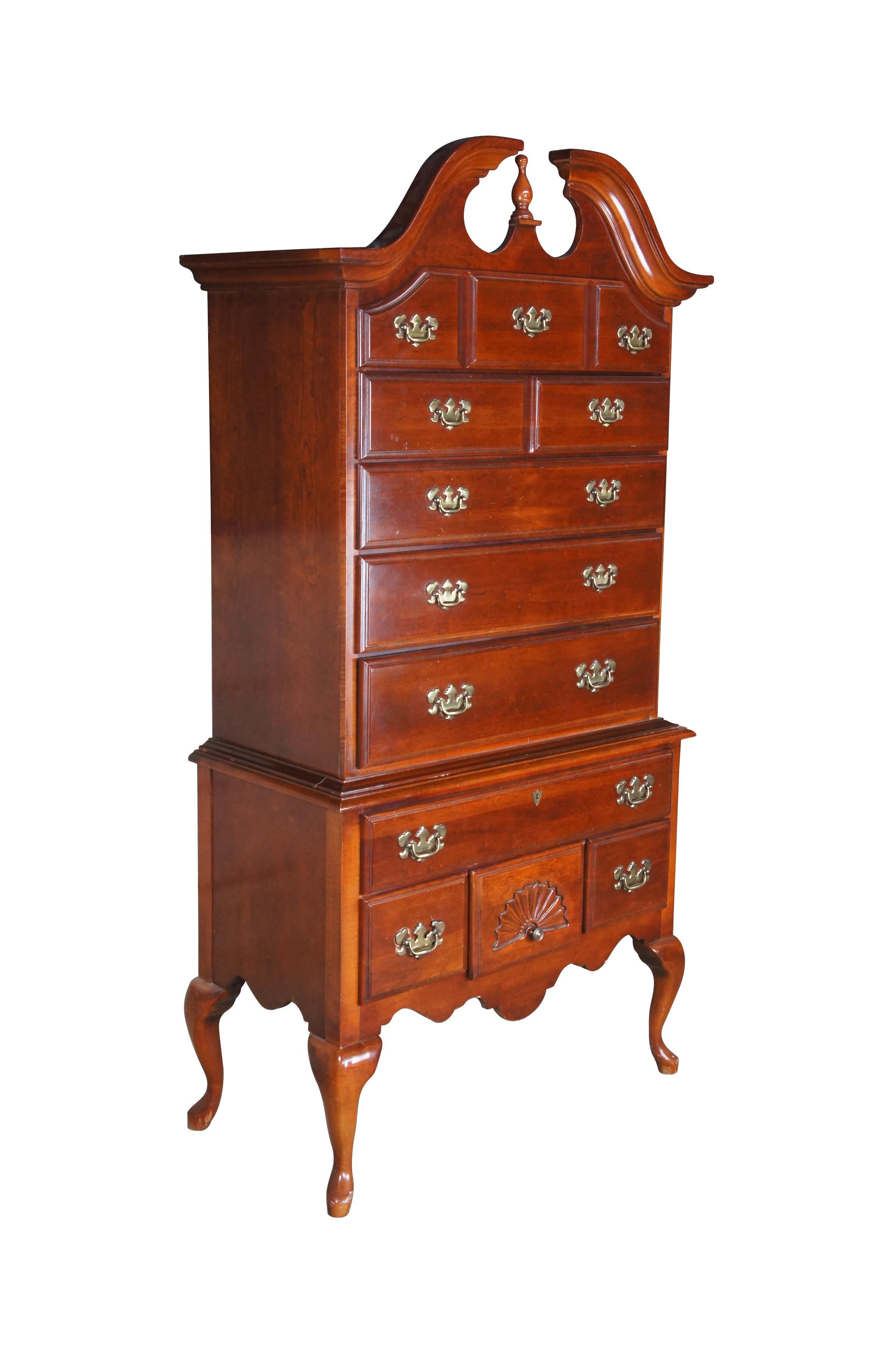 Vintage American Drew highboy chest or dresser.  A chest on chest design made of cherry featuring Queen Anne styling with open pediment crown over nine drawers with Federal style brass hardware and sepentine cabriole