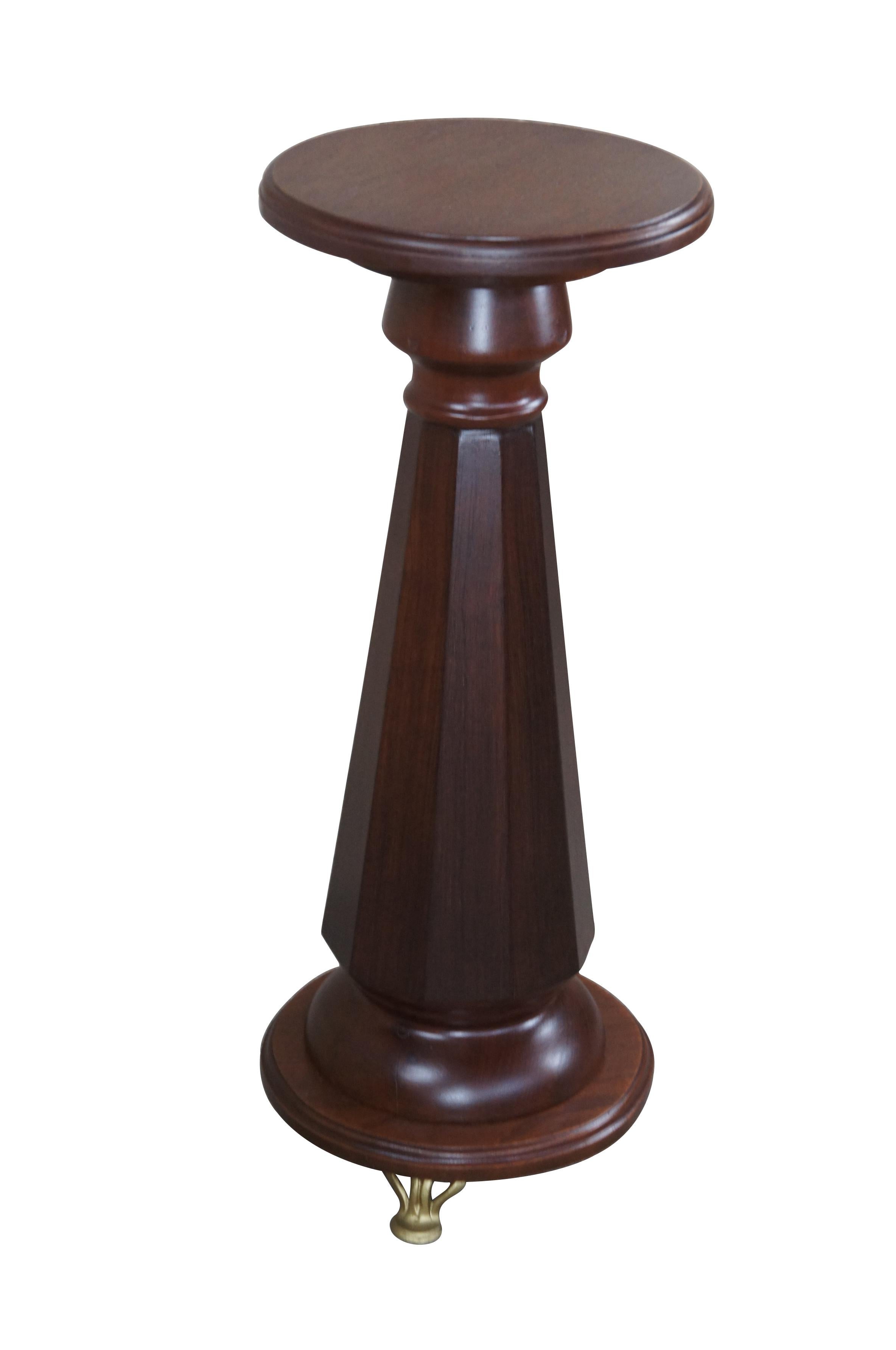 An American Empire style sculpture pedestal or plant stand, circa last half 20th century.  Features  an rounded top over a faceted graduated column leading to a rounded brass footed base.   

Dimensions:
28.5