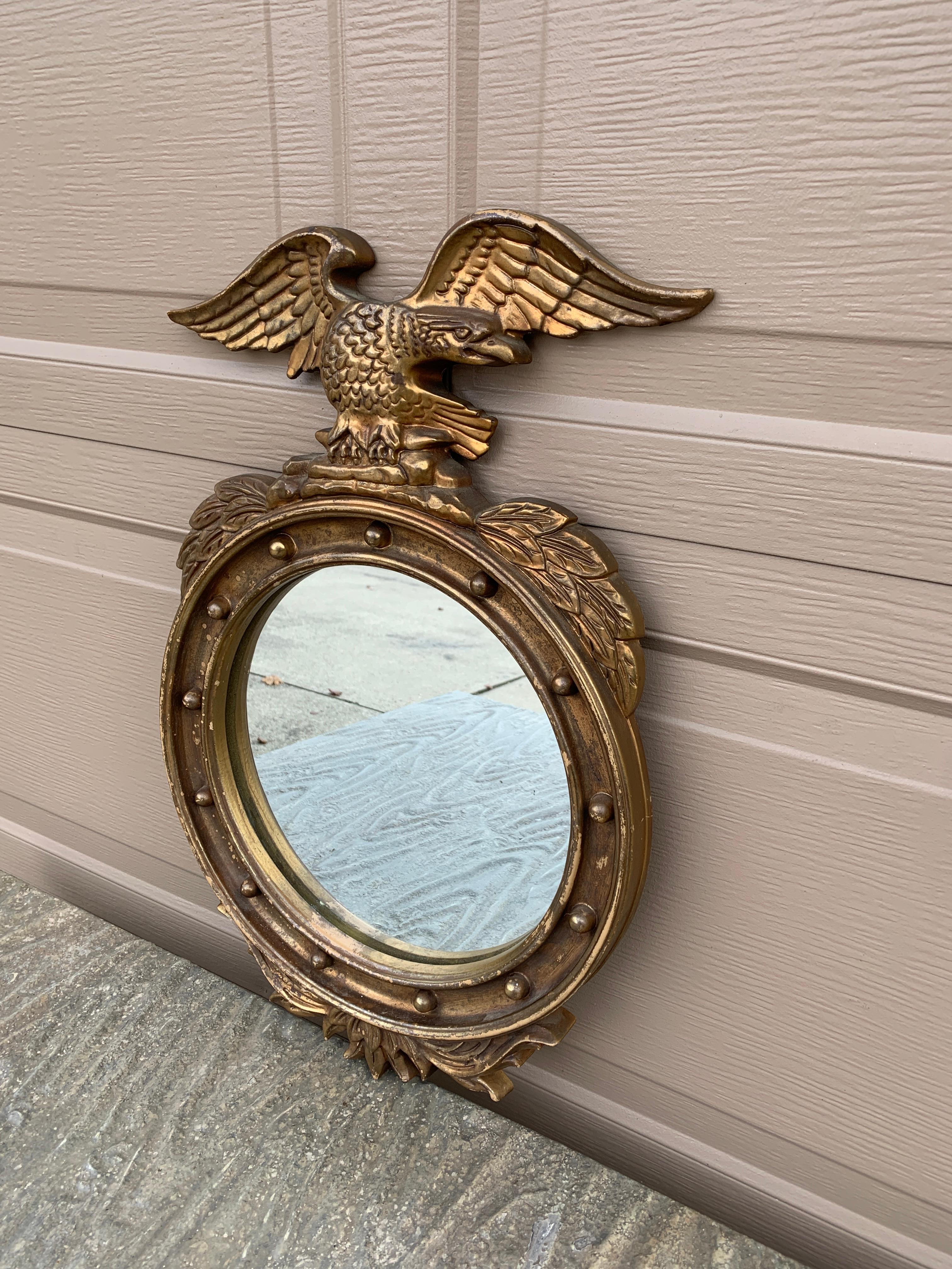 Magnifique miroir mural convexe de style Feder ou Regency avec un aigle sculpté aux ailes ouvertes se tenant sur des branches d'olivier et 13 petites sphères représentant les 13 colonies d'origine autour du périmètre intérieur.

États-Unis