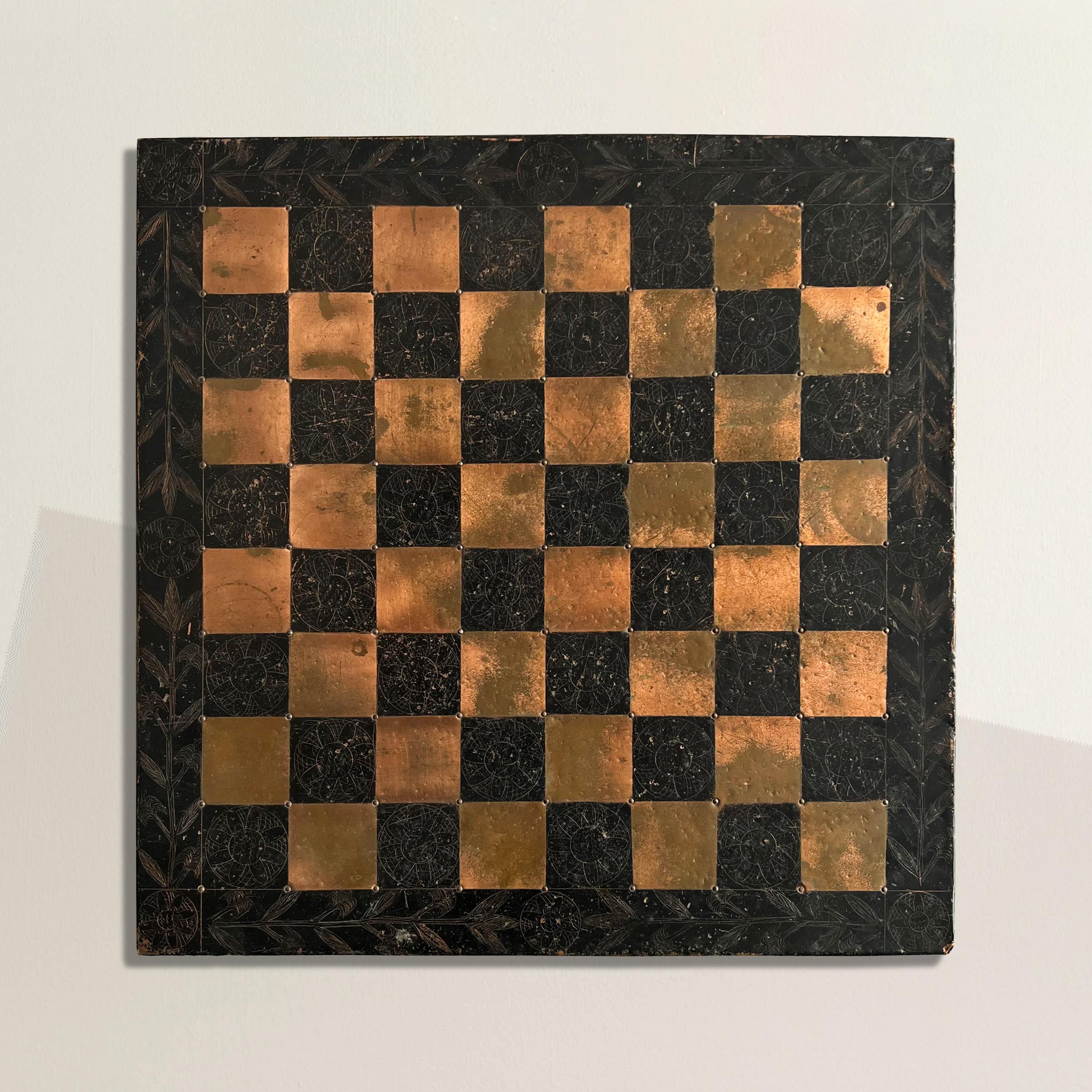 This enchanting mid-20th century American Folk Art chess board is a true testament to naive and outsider craftsmanship and creativity. Hand-crafted with meticulous care, the board features alternating copper and tin squares adorned with delicate