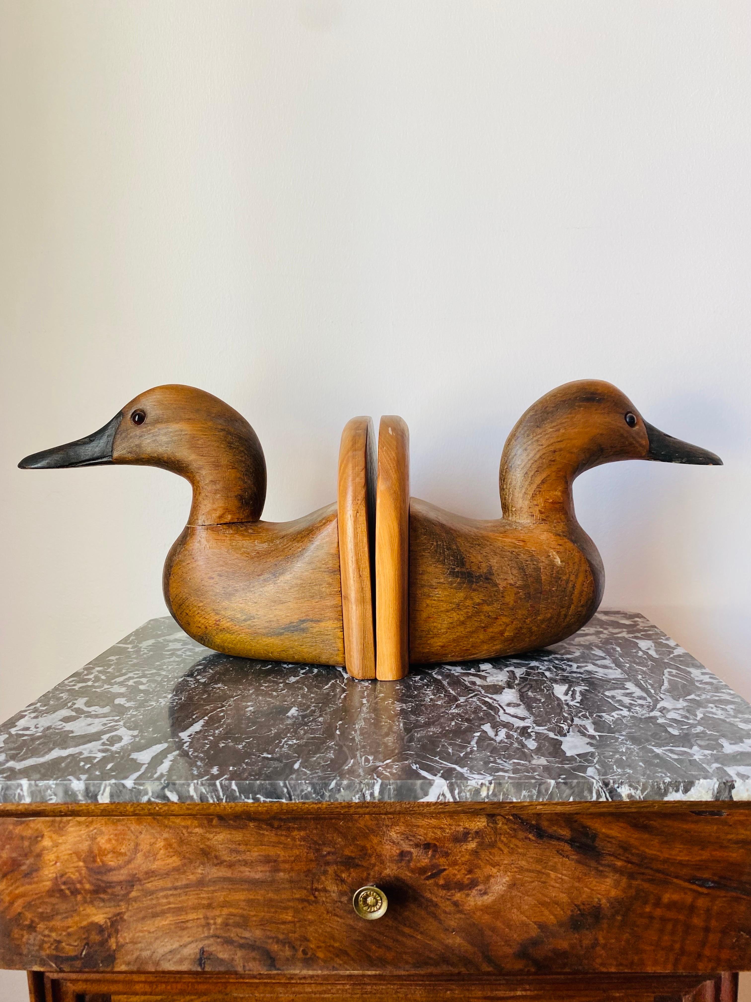 Beautifully sculpted and incredibly nostalgic pair of wooden decoy duck bookends. These realistic looking, duck bookends have a timeless and classic look. Made in the 1980's, these rare bookends are in excellent condition. Masterfully crafted in