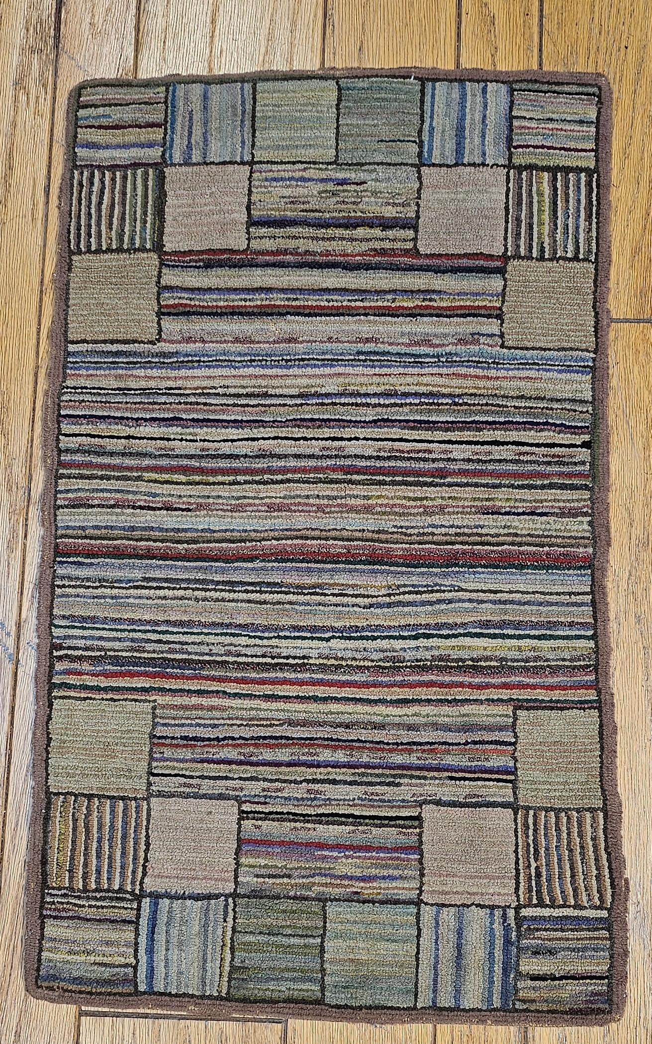 Vintage American hand hooked rug in a stripe pattern handcrafted in the 1st quarter of the 1900s.  The  hooked rugs from the late 19th and early 20th centuries are made with recycled old material, often used clothing that had been cut into narrow