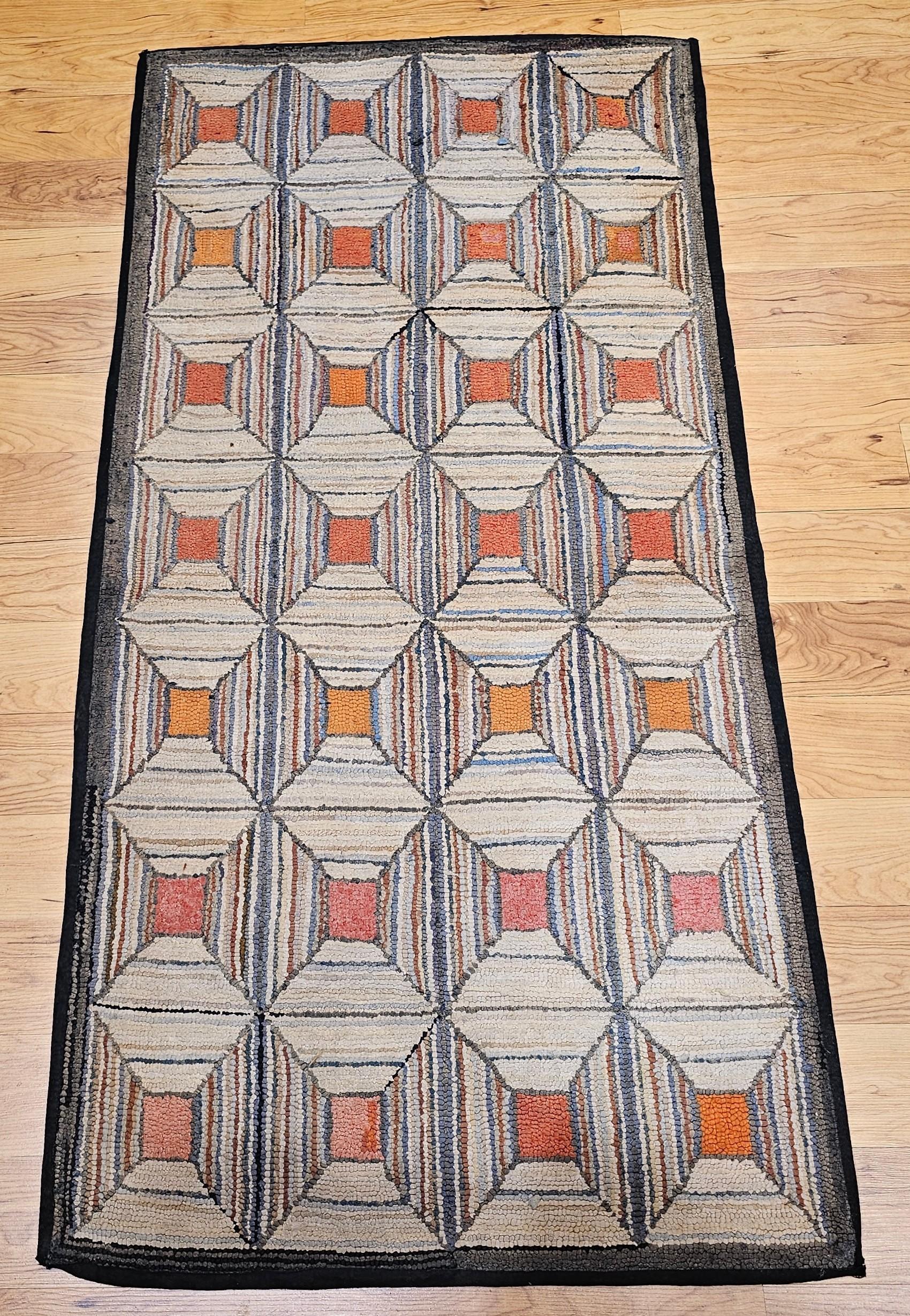  A vintage American hand hooked rug in a geometric pattern handcrafted in the 4th quarter of the 1800s in the New England Area of the United States.  The design of each block gives the impression of looking down a funnel with the solid color in the