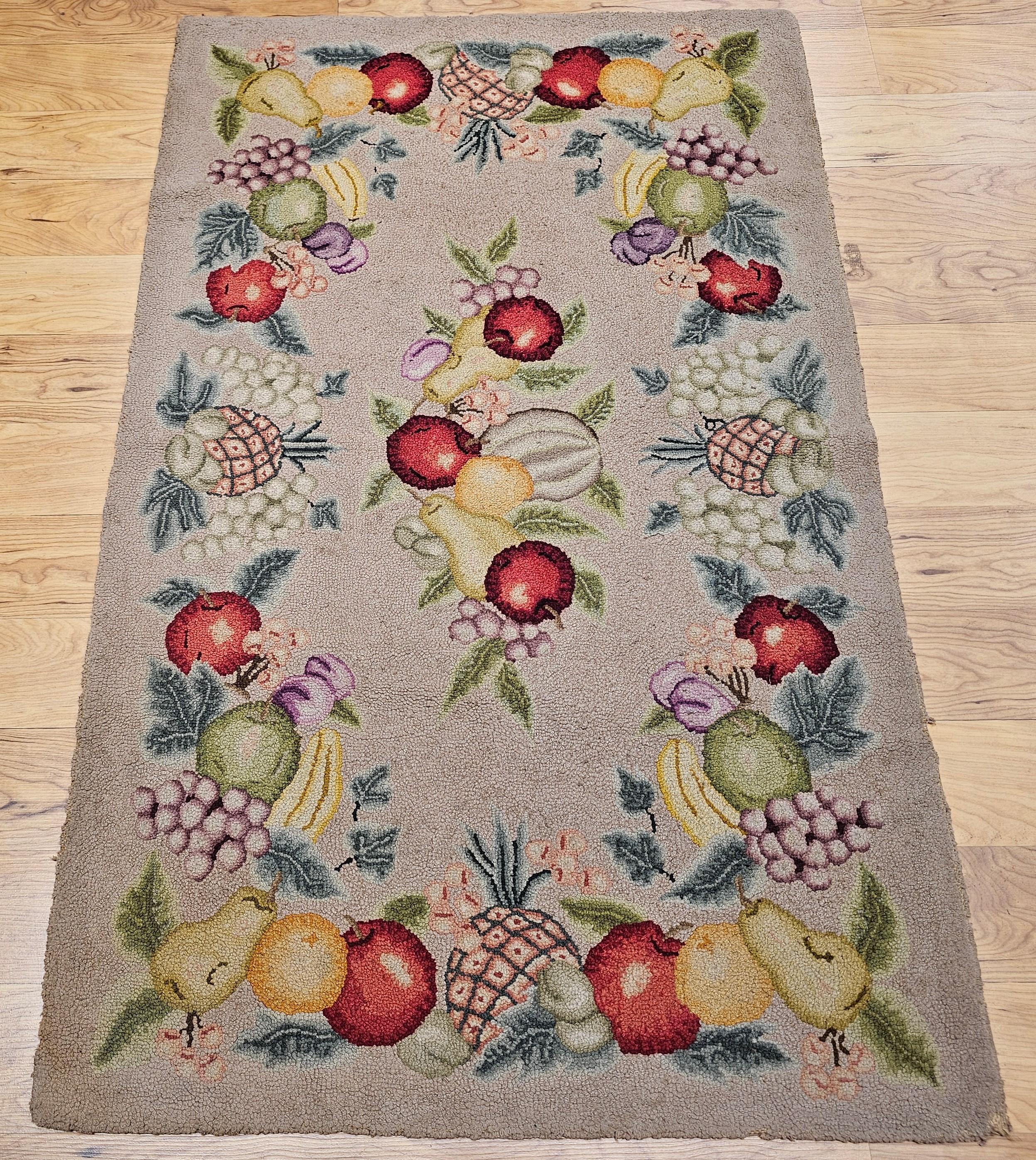Vintage American hand hooked area rug in a fruit pattern circa the early 20th century.  The very unique and beautiful design in this vintage folk art hooked rug consists of a fruit pattern consisting of the design of various fruit grouping around