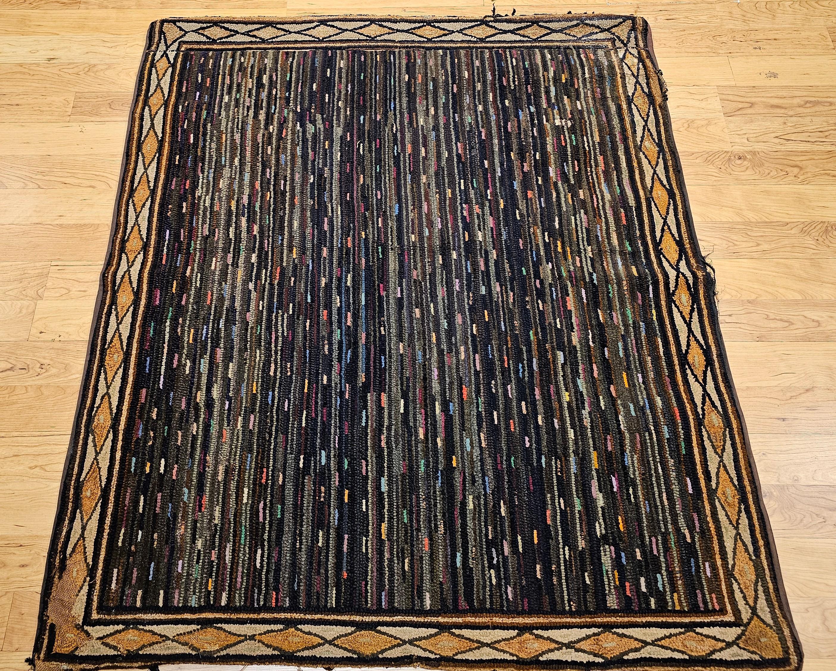 Vintage American hand hooked area rug in geometric pattern circa the early 20th century.  The rug has a wonderful narrow parallel line pattern with a navy blue background and stripes in many shades of green, blue, red, pink, brown and purple.  The