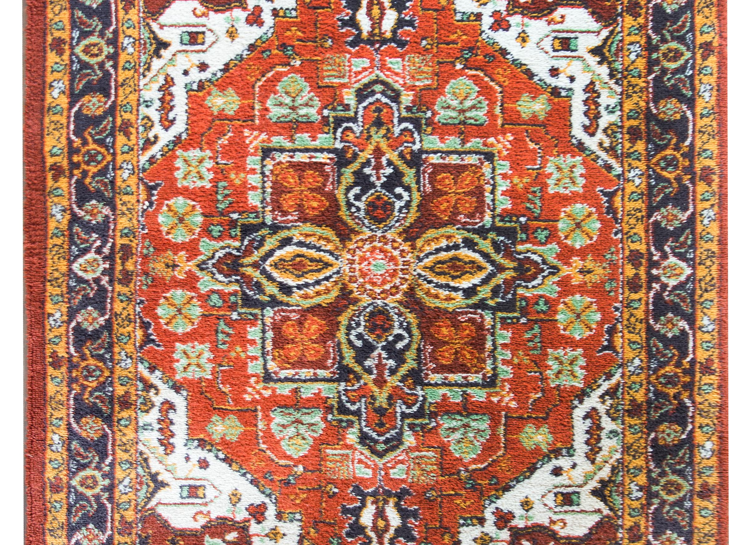 A chic late 20th century American hand-knotted Keristan rug with a Heriz-style pattern including a large central floral medallion living amidst a field of even more stylized flower and leaves, and surrounded by a complex border with multiple large