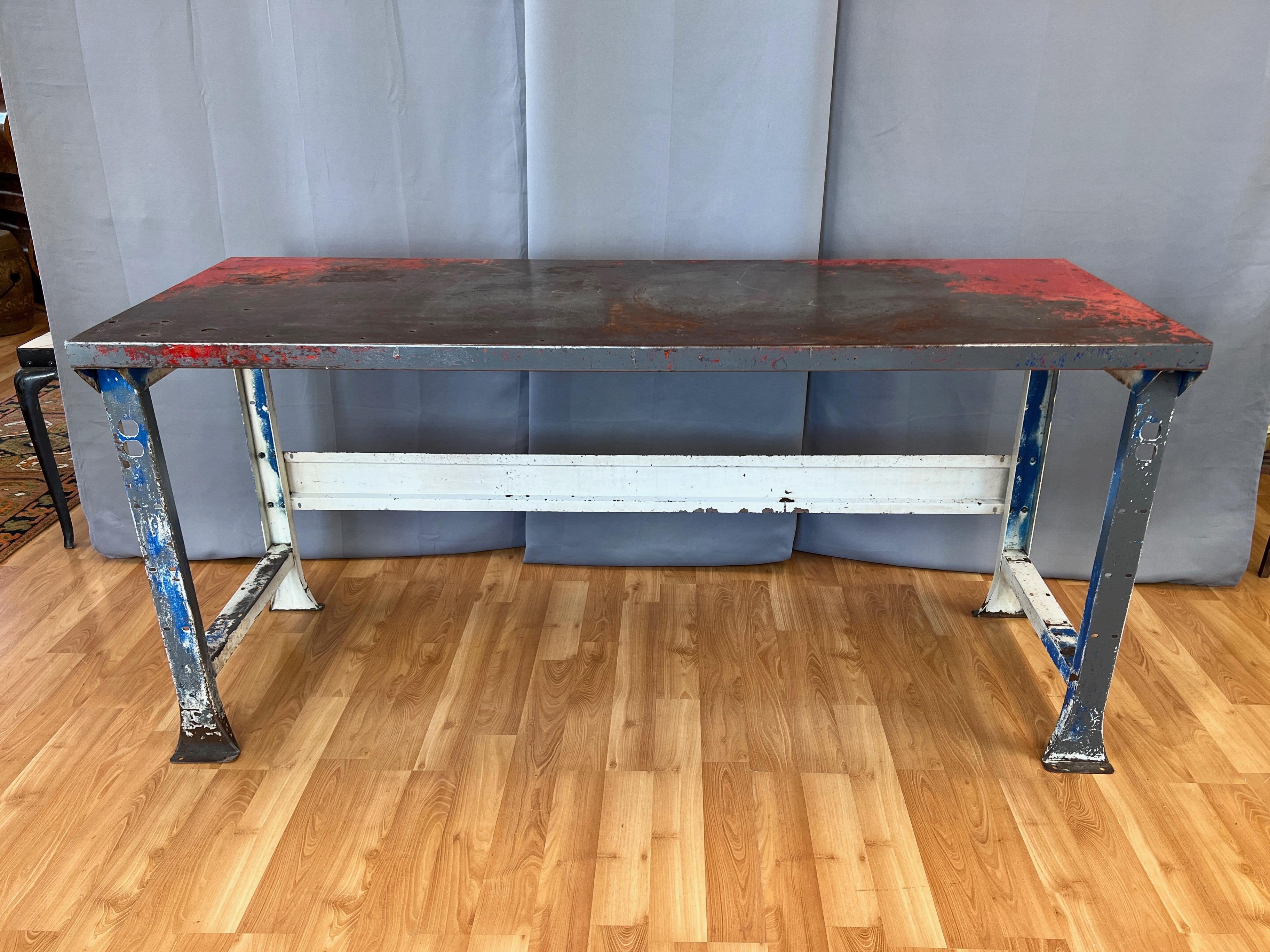 A circa 1940 American six-foot-long painted steel work table or work bench with fantastic industrial character.

Features authentically earned vintage character from top to bottom. Patriotic red, white, & blue (and a bit of battleship grey) paint,