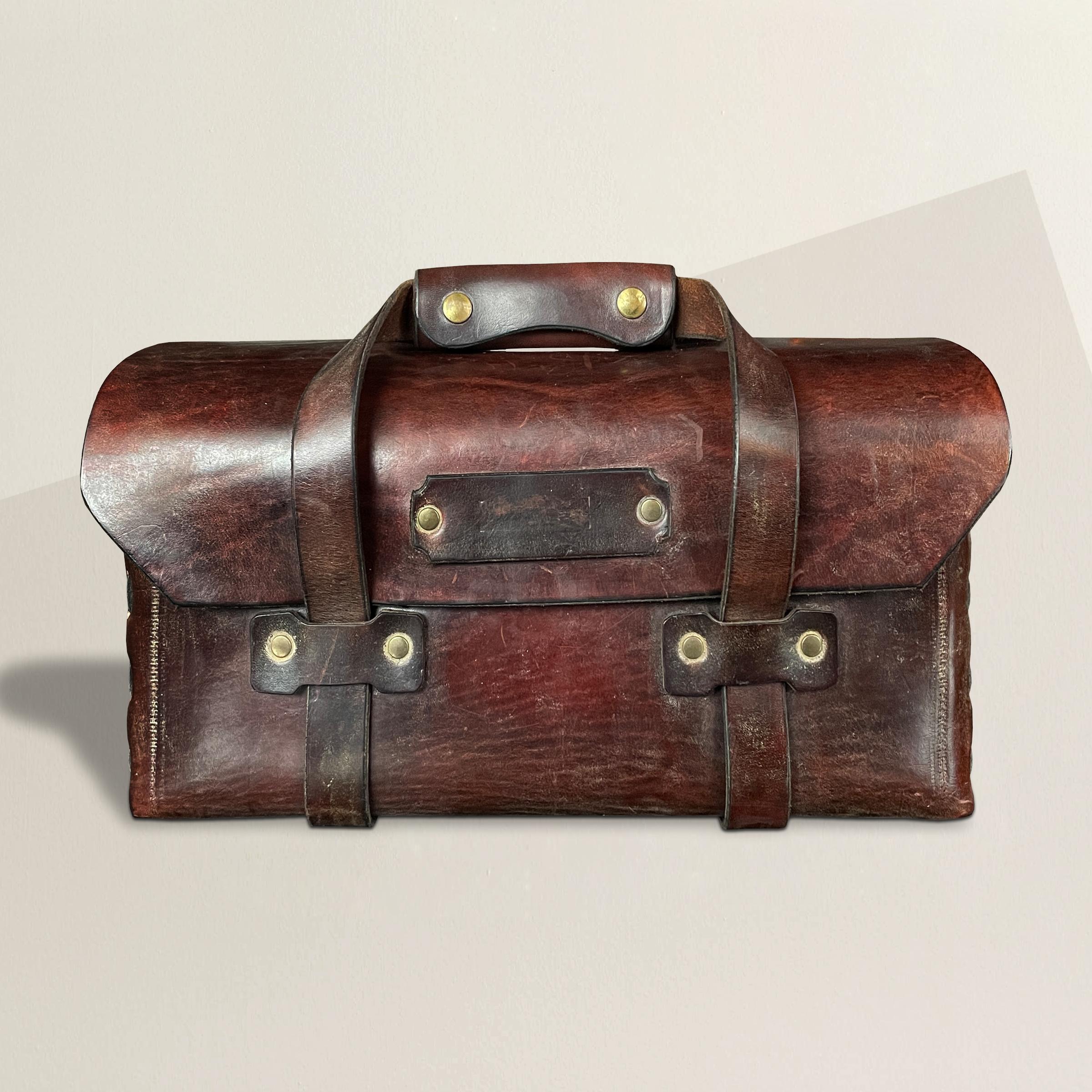 A wonderful mid-20th century American leather tool bag with two leather strap handles with brass snaps, and two elastic pockets inside. The perfect bag for the remotes on your coffee table, or anything else you might need to organize around your