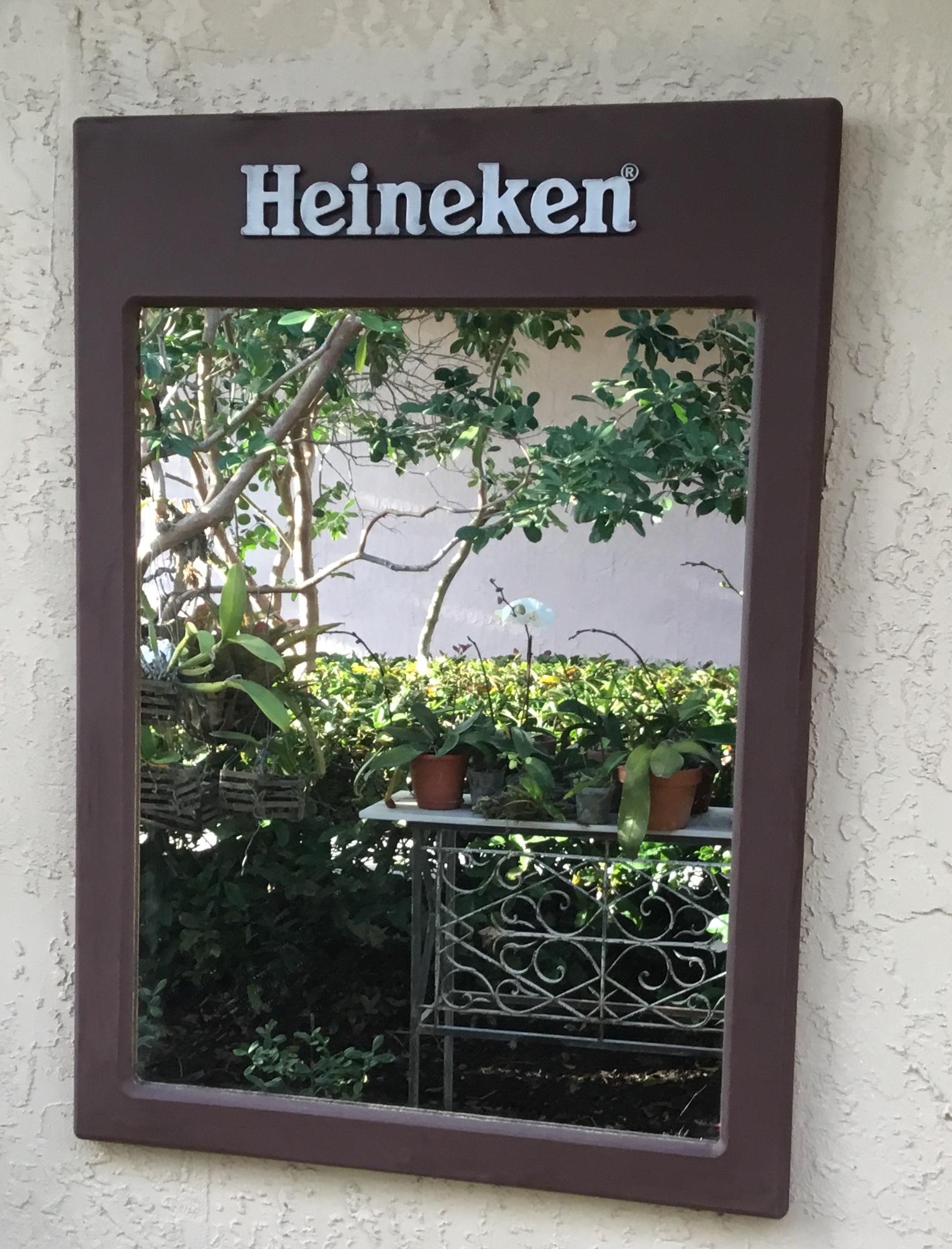 Elegant vintage wall handing mirror made of wood composite, with the advertising label of the famous beer brewery Heineken, this mirror was probably hang in a bar or restaurant and could
Be a decorative item in the right place. The glass mirror was