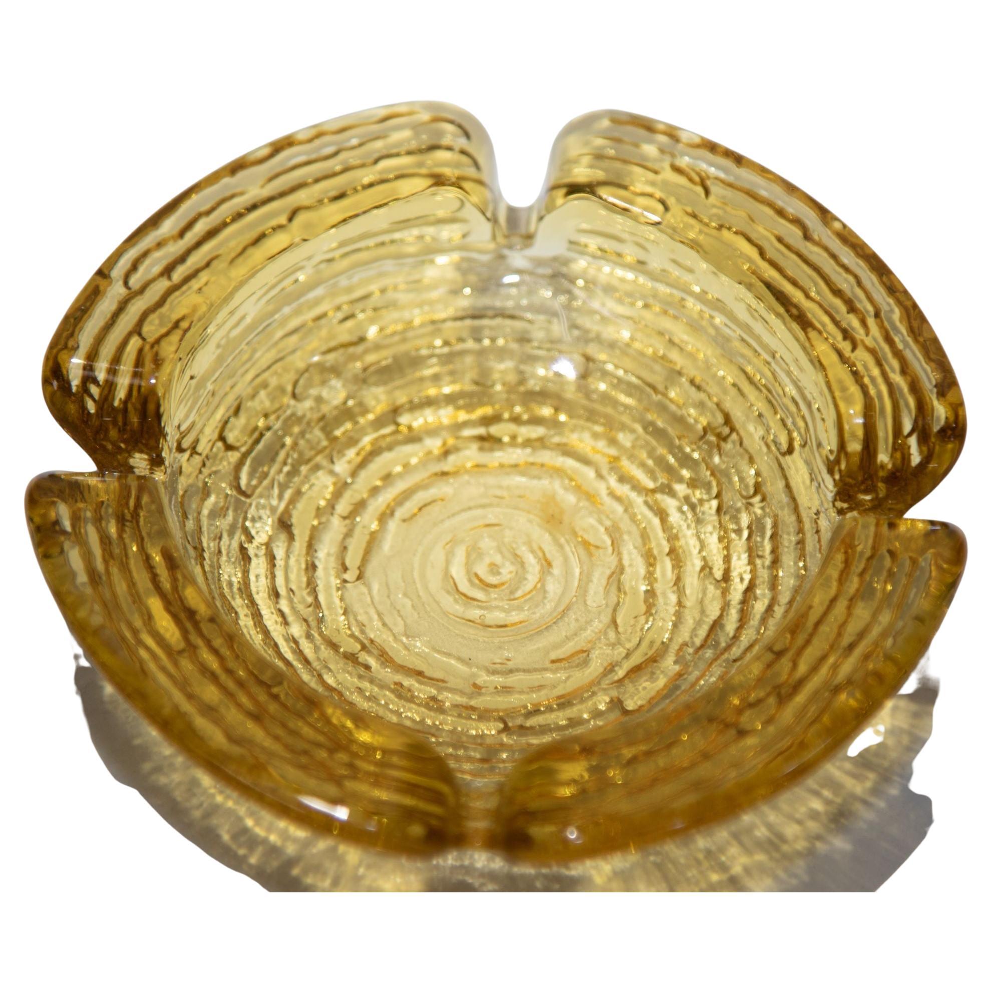 Vintage American midcentury textured round amber glass ashtray.
Soreno Amber ashtray by Anchor Hocking in the Heritage Gold color.
Moroccan amber glass ashtrays from the 1960s.
Vintage solid glass amber ashtray with a circular bumpy pattern on