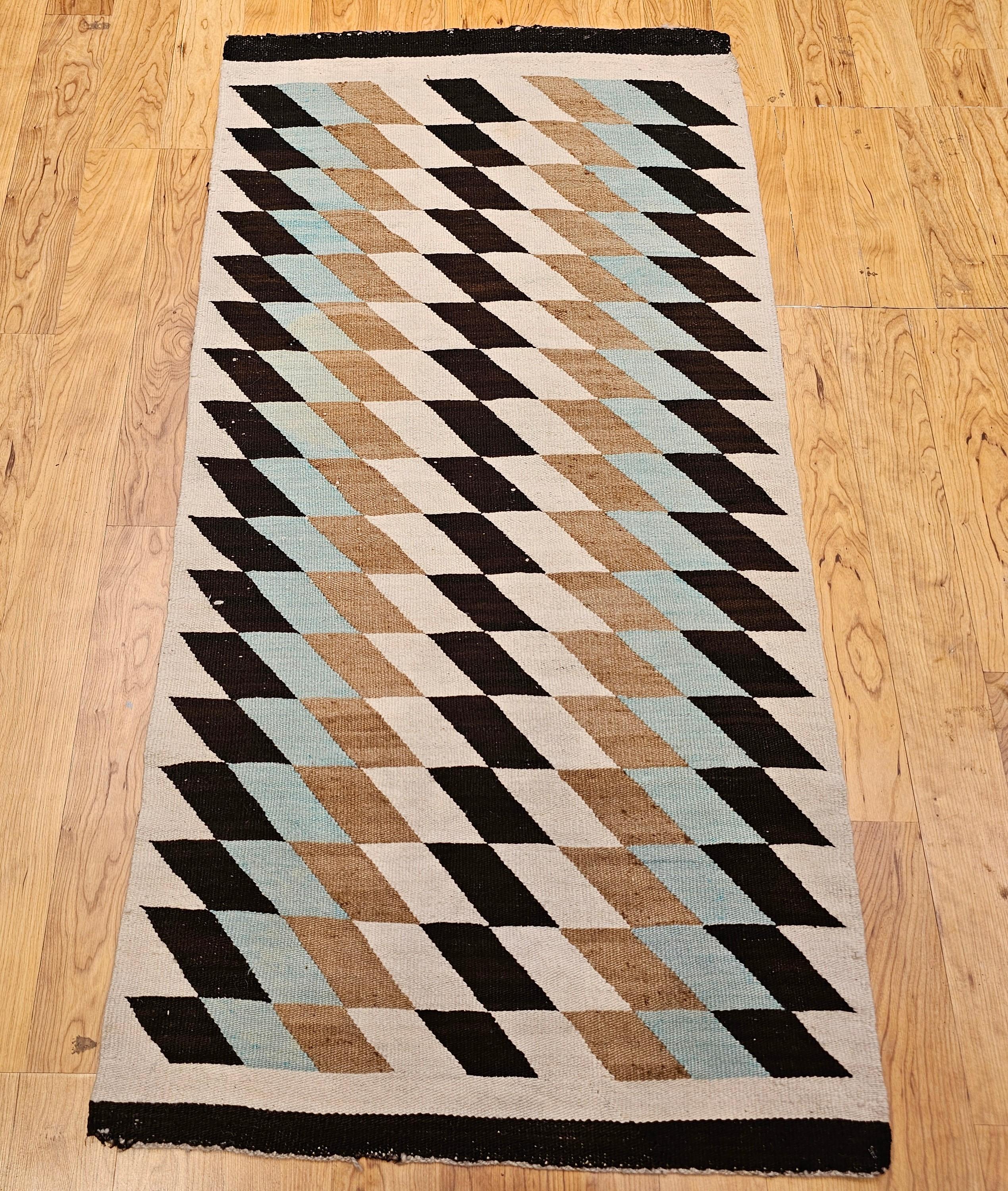 This exquisite vintage Navajo rug, dating from the mid-20th century, is a striking example of traditional Native American textile art. Handwoven by a Navajo artisan, the piece features a bold block pattern rendered in a harmonious palette of