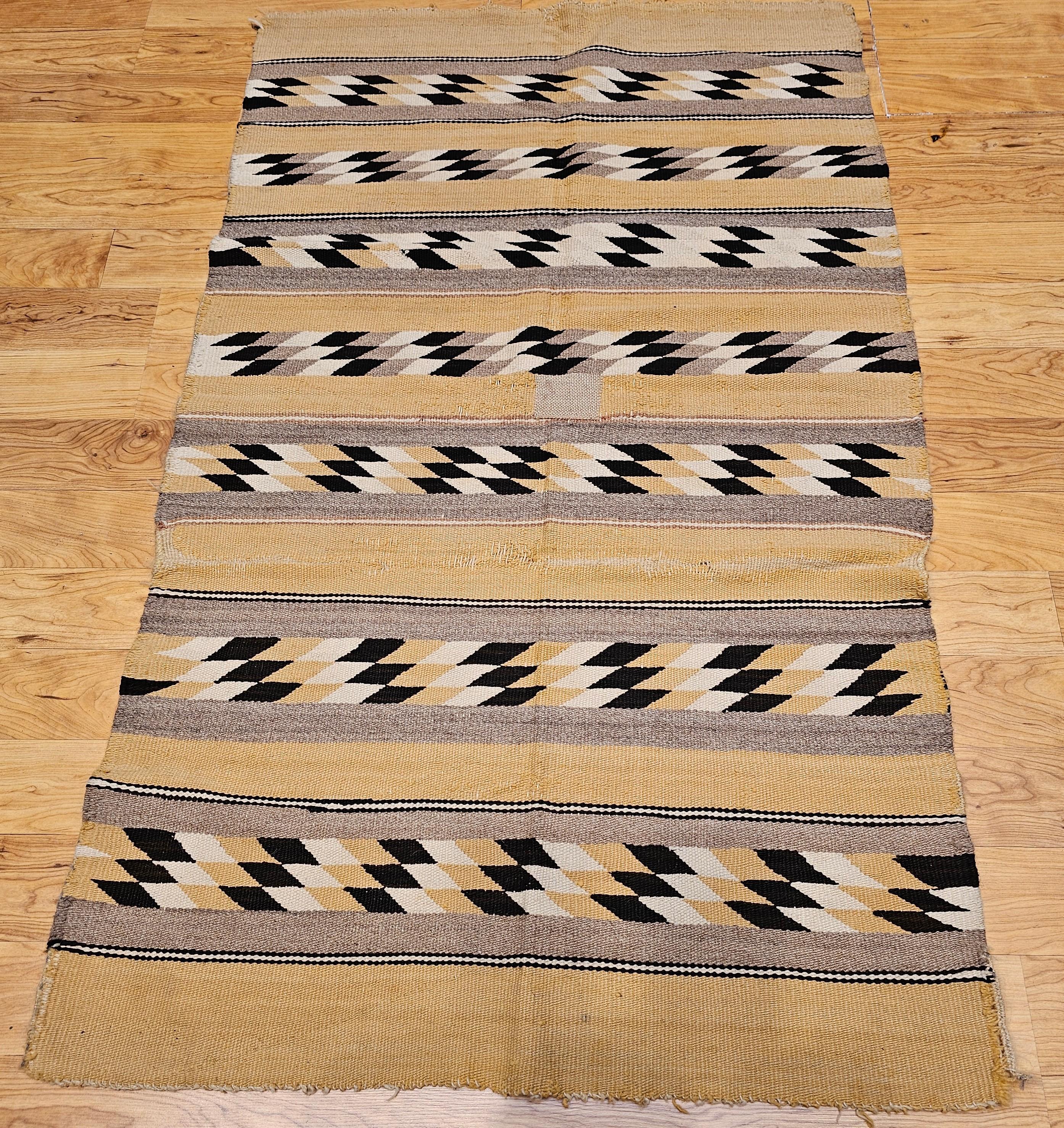 Vintage Native American Navajo Rug in a Chinle revival pattern in earth tone colors including cornmeal, brown, black, ivory, and gray.  The vintage Navajo rug is woven of native hand-spun wool in a Chinle revival pattern. This style of Navajo