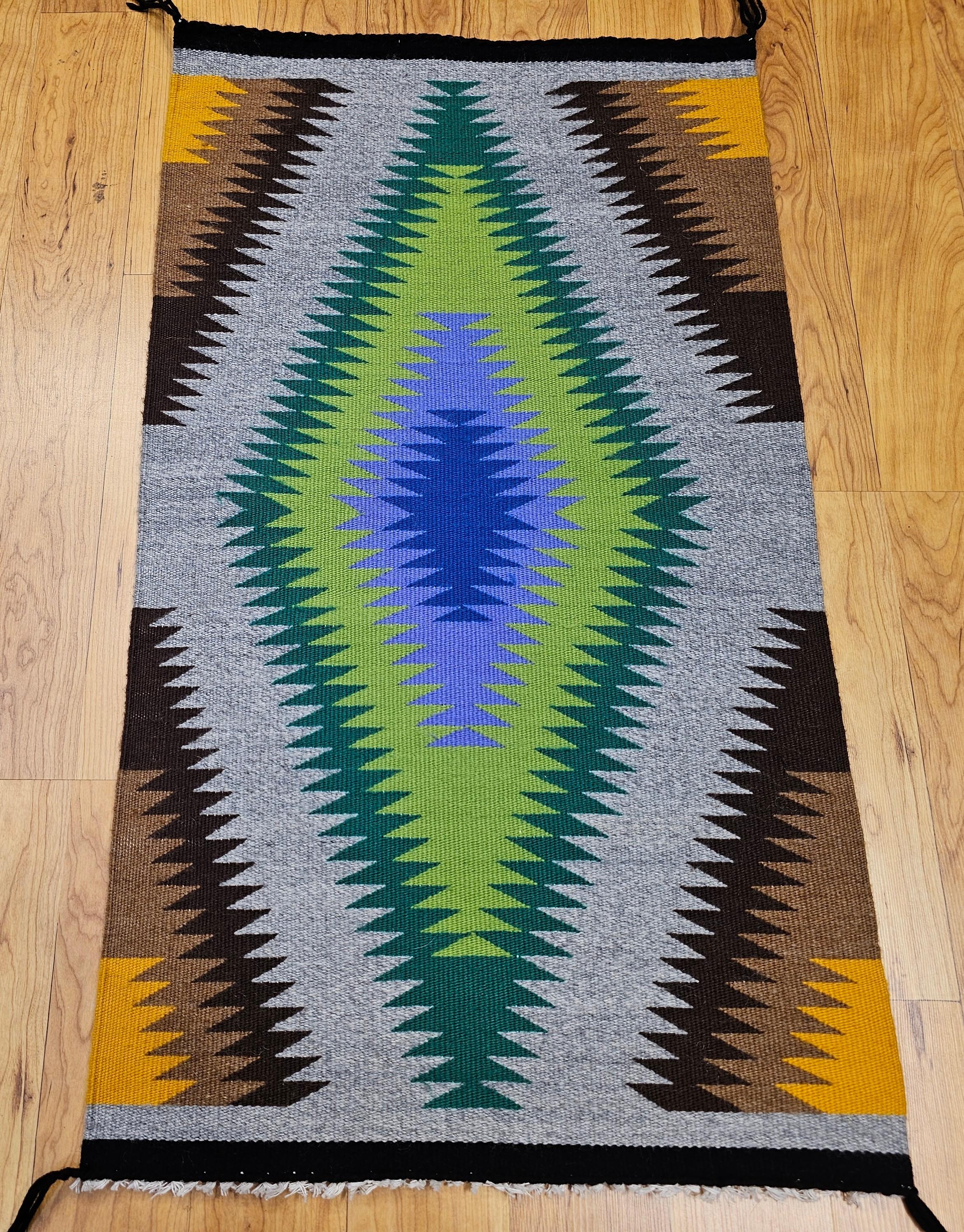 A stunning mid-20th century Navajo weaving from the American Southwest, this vibrant rug showcases an extraordinary radiating diamond motif that transitions through a color spectrum of natural tones. Beginning at the center with cool shades of blue