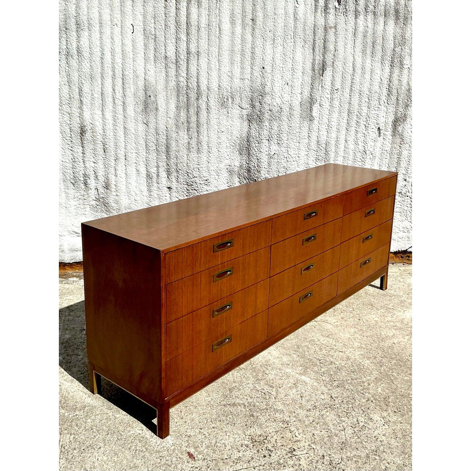 This stunning mid-century modern dresser by American of Martinsville is a true statement piece, blending sleek lines with impeccable craftsmanship. Featuring a beautifully grained wood veneer, this 12-drawer dresser offers ample storage while