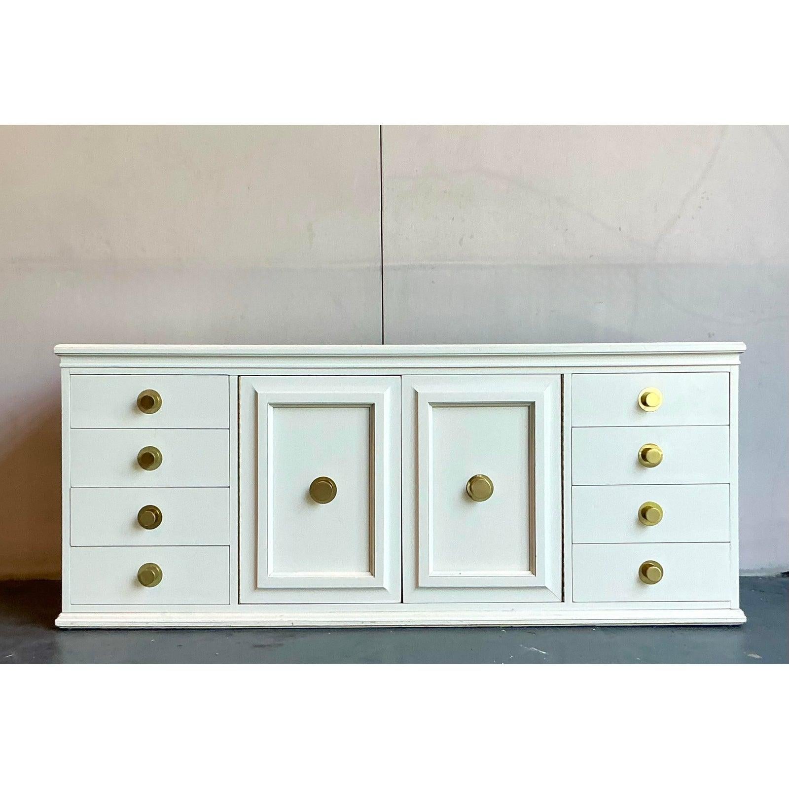 Eleva i tuoi interni con questa iconica credenza vintage del celebre produttore americano American of Martinsville. Questo pezzo è stato laccato professionalmente in un elegante e morbido bianco, dando nuova vita alla sua classica silhouette