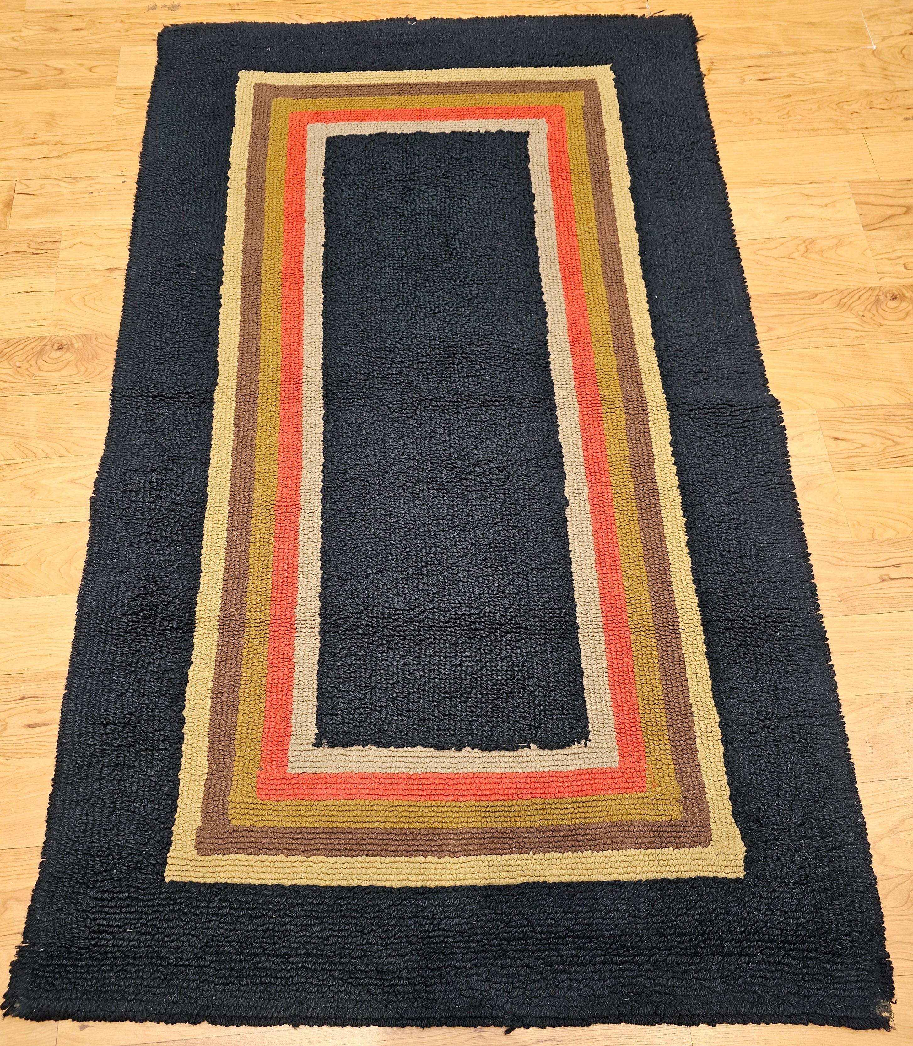Tapis de sol vintage American Rag dans un coloris ouvert multicolore  de champ datant du début des années 1900.  Les couleurs comprennent le marine, le brun, le rouge, l'ocre et le tan. Le motif du tapis consiste en un certain nombre de rectangles