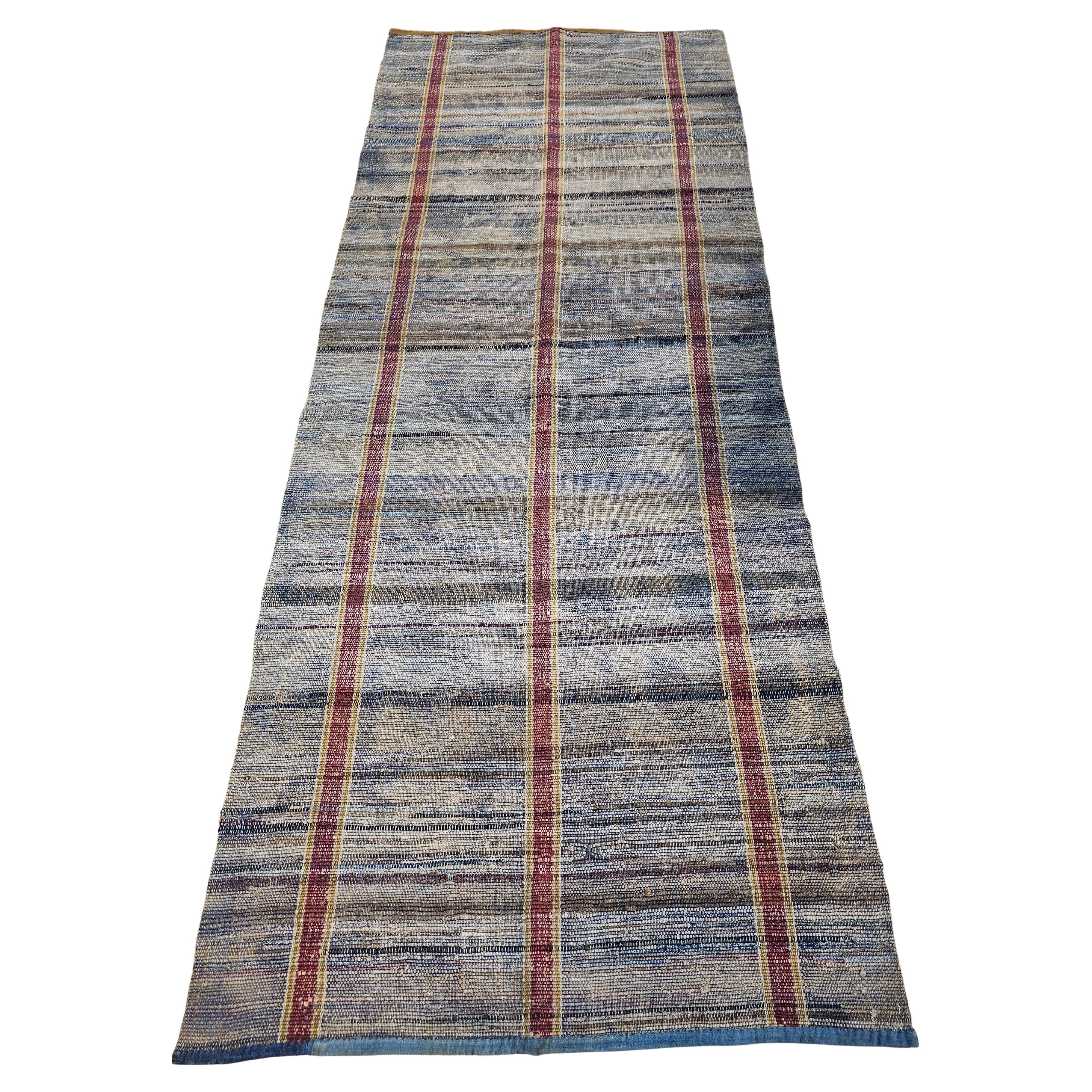 The vintage American Rag Runner has a pale blue background with three primary sets of vertical purple and green stripes and varied colors of horizontal stripes which brings that folk-like design to the rug.  The Rag area rugs and runners are  Ideal
