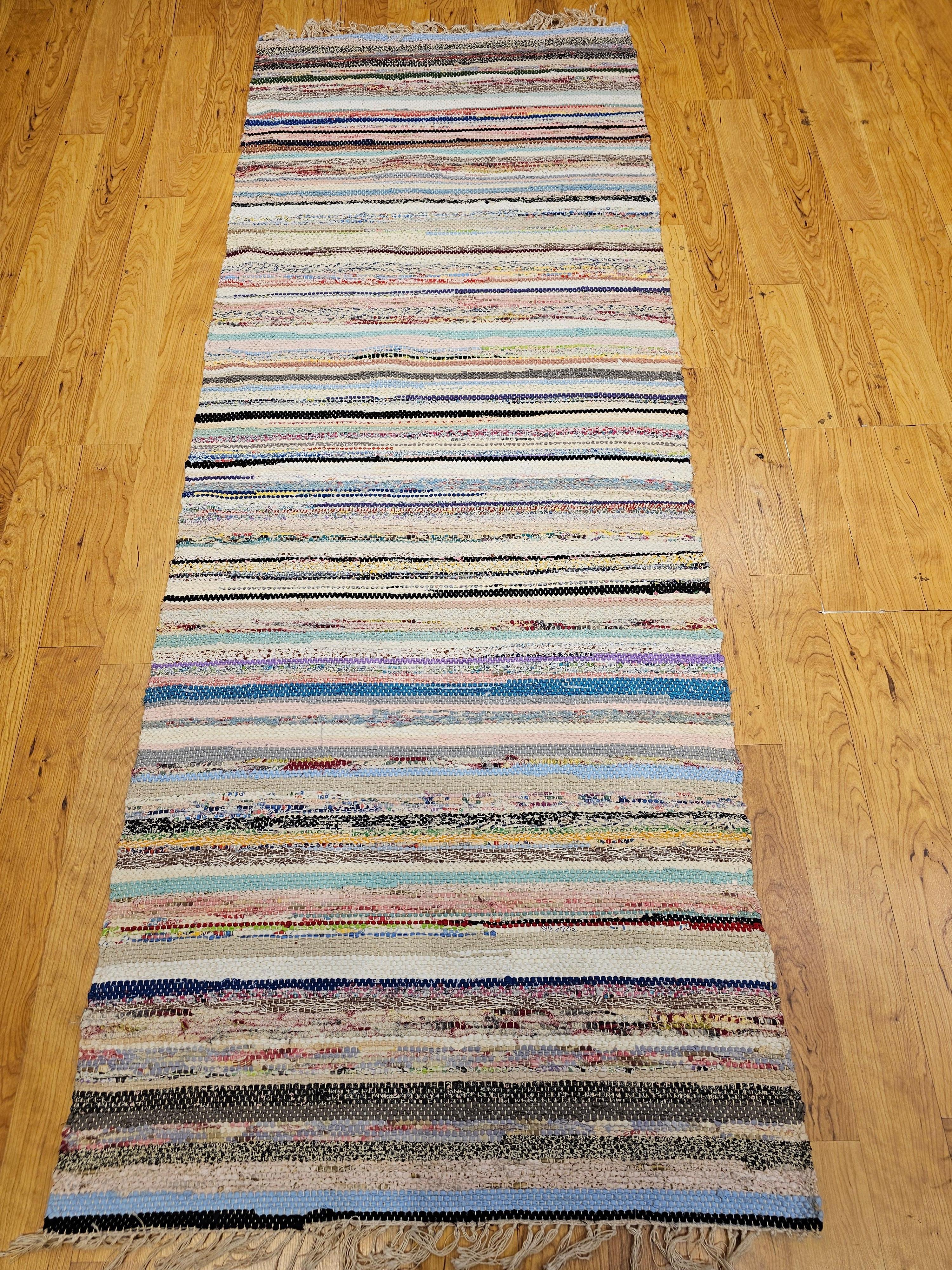 Discover the charming blend of sustainable design and timeless style with this beautiful Mid-20th Century Vintage American Rag Runner, handcrafted in the mid-1900s. This captivating runner is formed from a series of harmonious bands in a vibrant