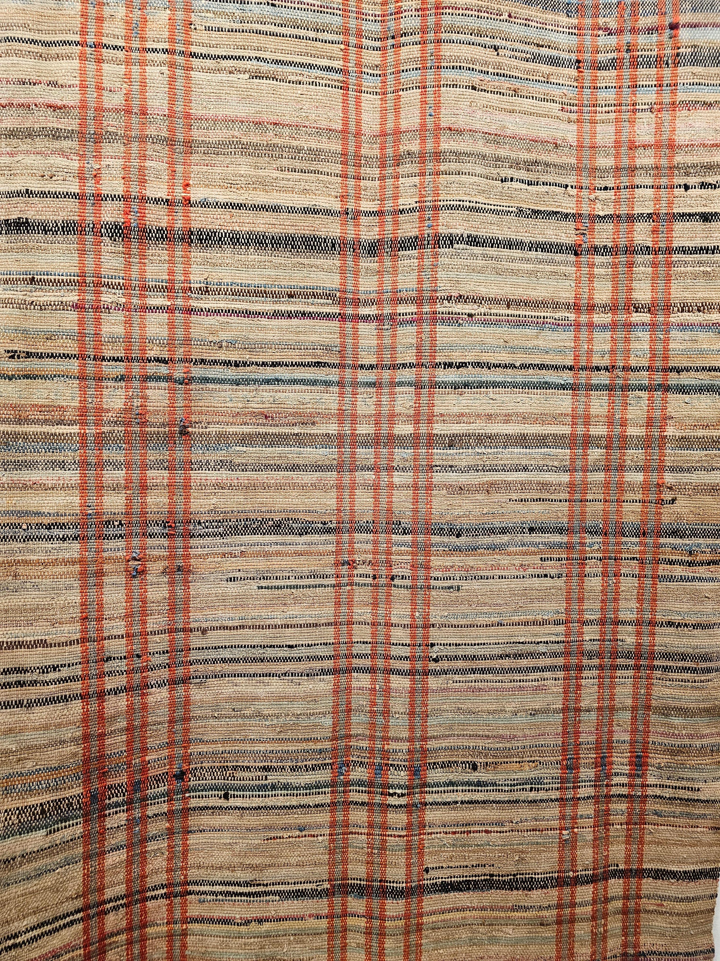 The vintage American Rag Runner has a tan background with three primary sets of vertical red stripes and varied colors of horizontal stripes which brings that folk like design to the rug.  The Rag area rugs and runners are  Ideal for a mid-century
