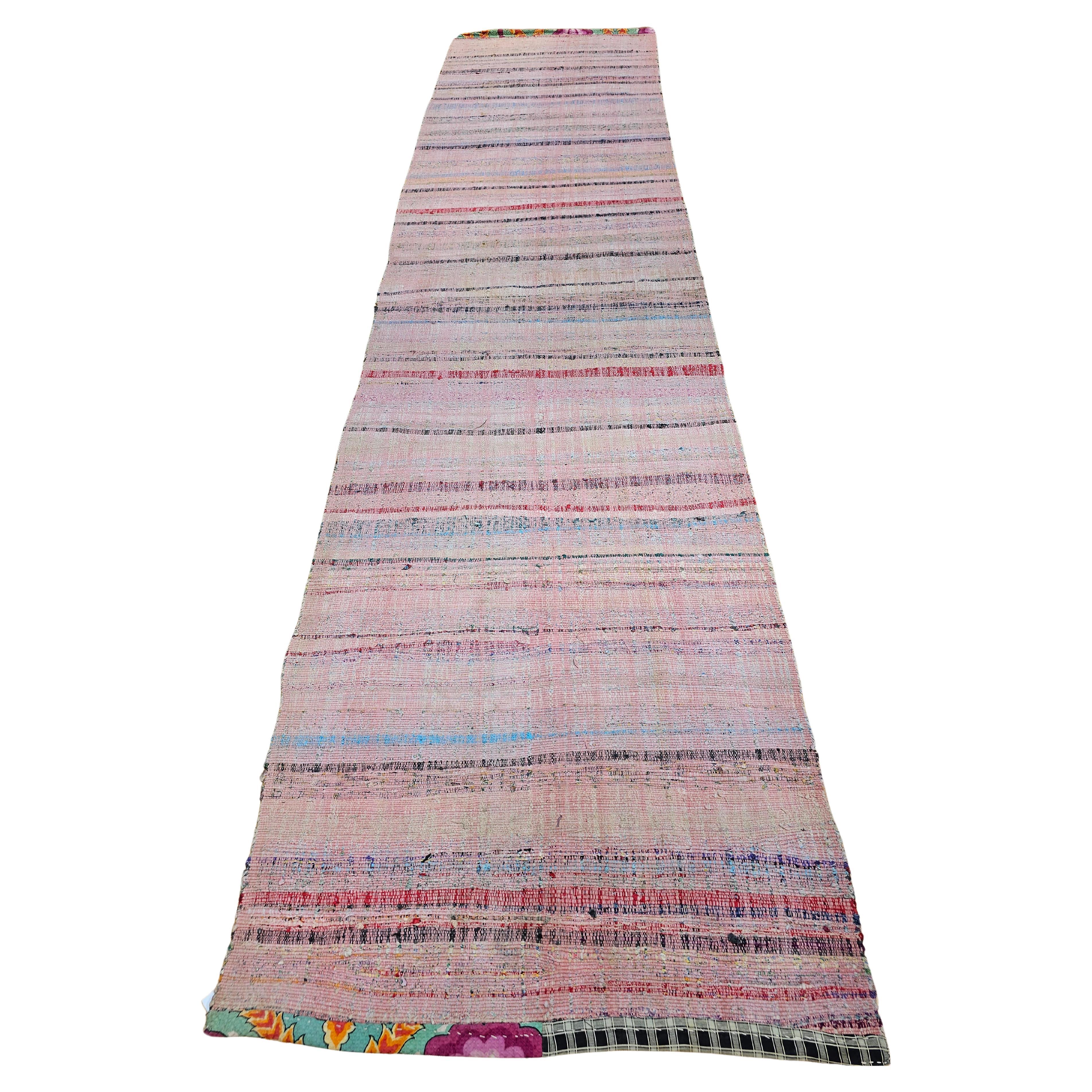 Un magnifique et coloré chemin de table vintage américain (tissé à plat) en motif de rayures avec une belle combinaison de couleurs incluant le rose, le vert, le bleu, le rouge et le jaune.  Le coureur se présente sous la forme d'un format large et