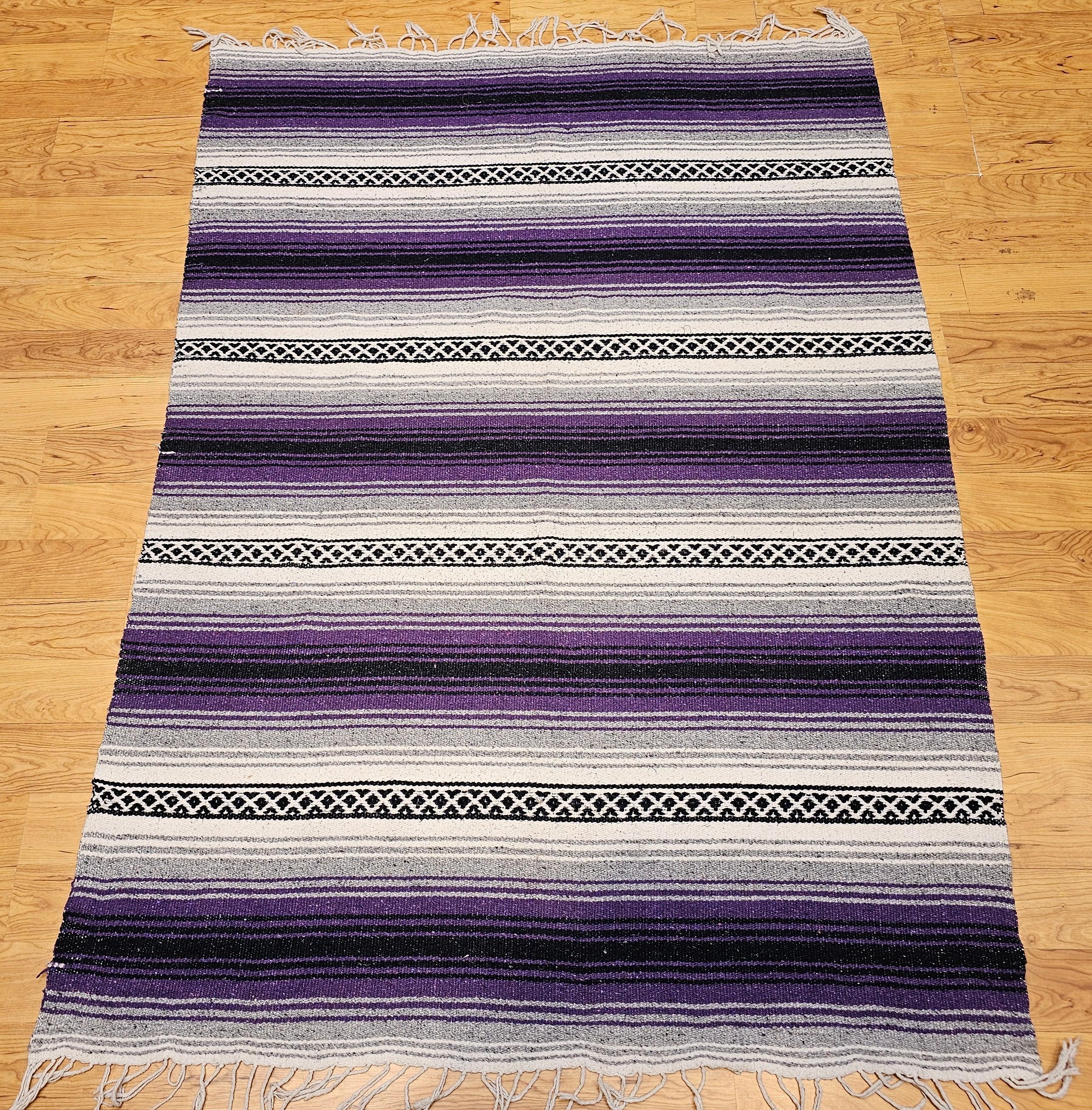 Vintage American Southwestern Kilim in alternating wide and narrow stripe pattern separated by narrow geometric bands in brilliant colors of lavender, gray, black and ivory.    The kilim is a flat woven rug so both sides of the rug can be used.  The