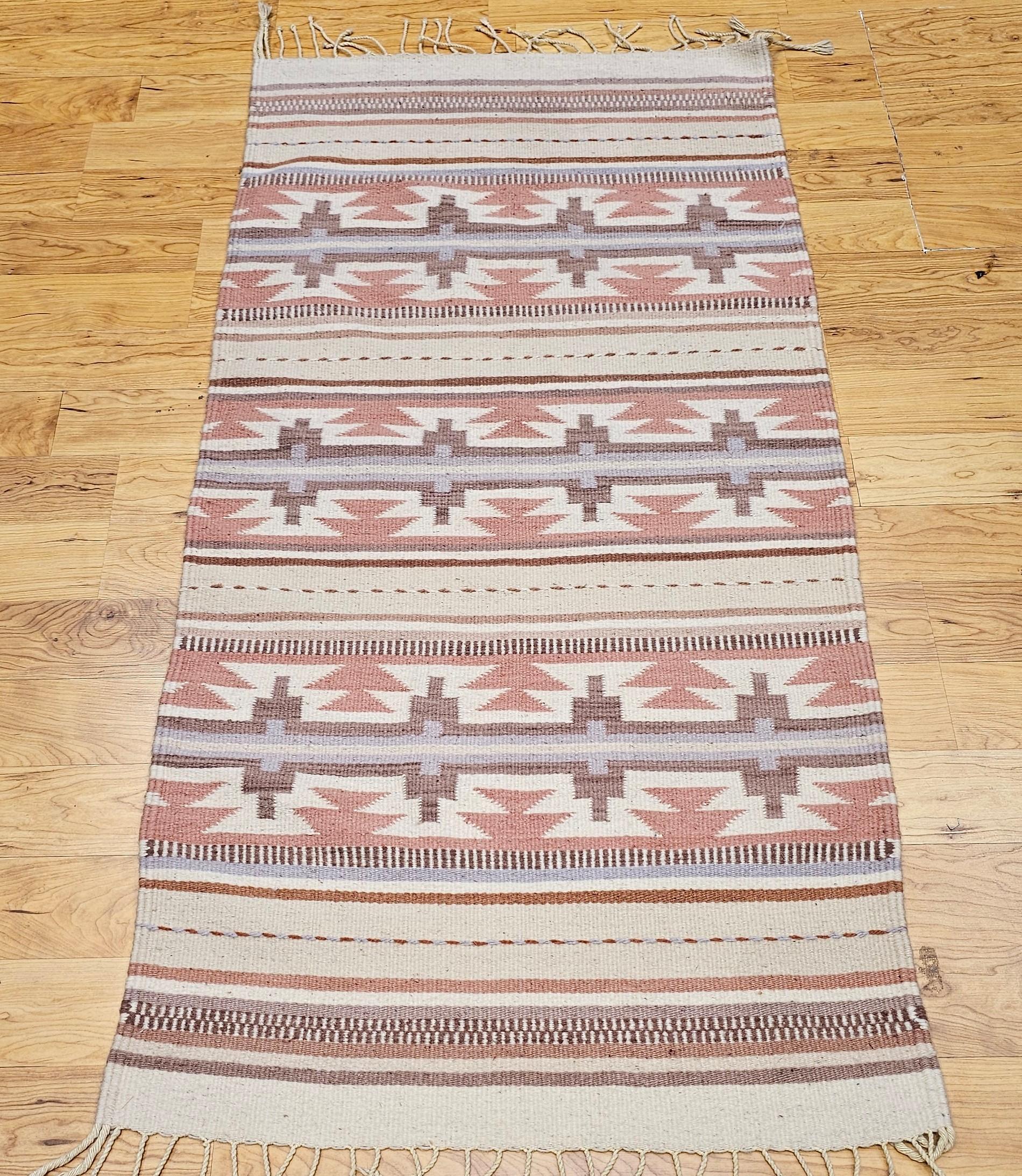 Ajoutez un charme intemporel et une richesse culturelle à votre espace avec ce tapis kilim vintage du sud-ouest américain, datant de la fin du 20e siècle. Doté d'un motif à rayures saisissant inspiré des tapis Chinle traditionnels du Sud-Ouest, ce