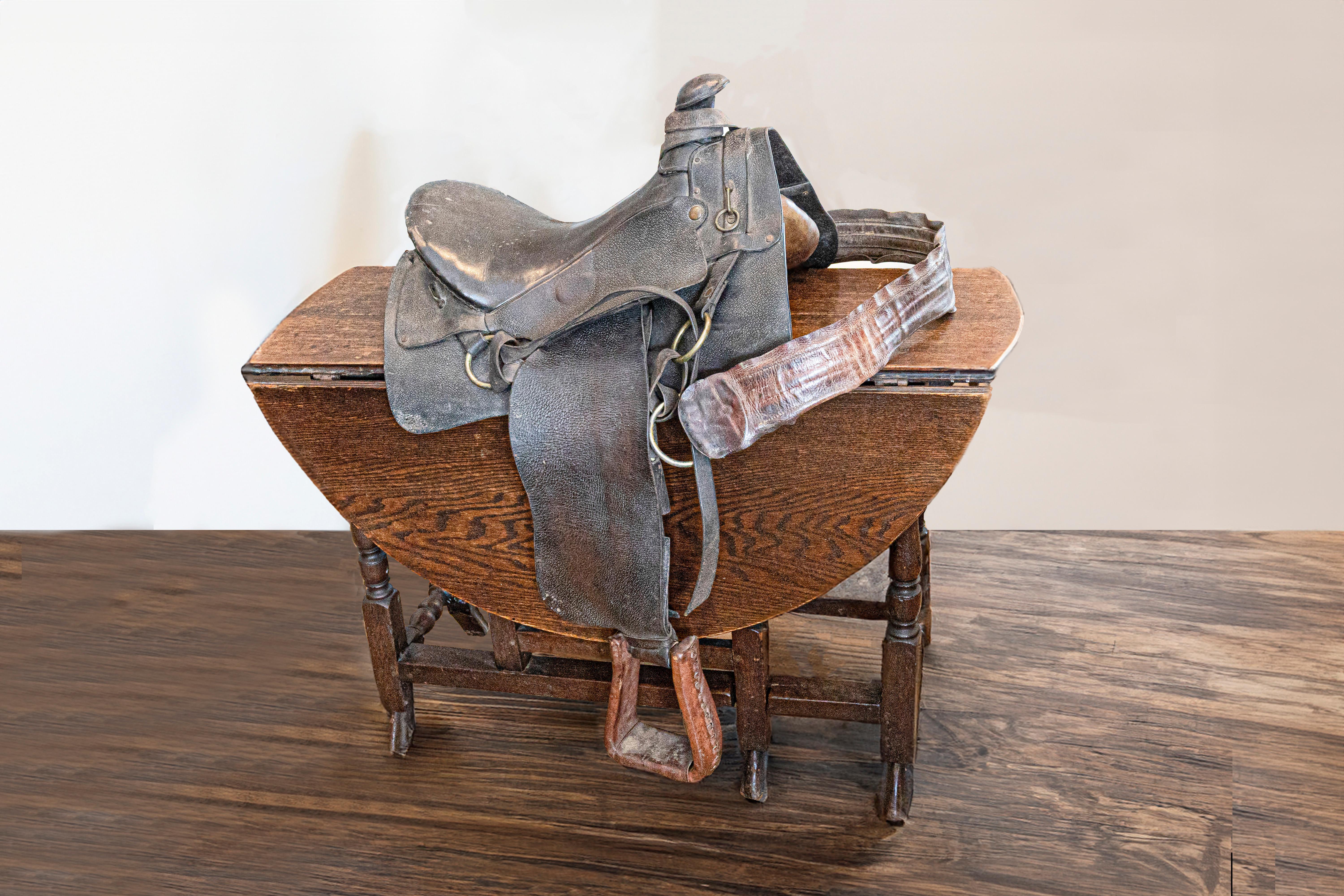 An American Western style leather saddle from the 20th century, with dark brown/black seat, jockey, fender, horn and lighter brown stirrups. Handcrafted in America during the 20th century, this leather Western style saddle boasts a nice patina