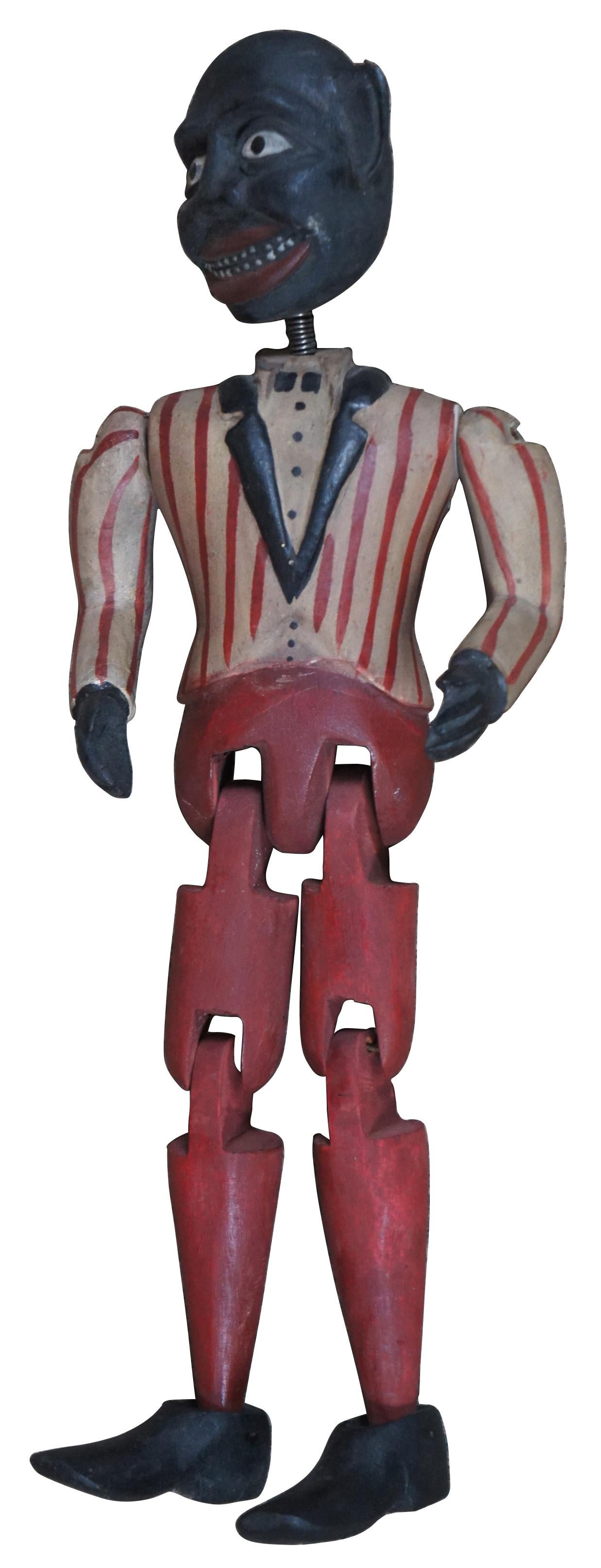 Vintage Americana, folk art style hand carved wooden jig or limberjack toy doll, dancing Minstrel puppet, with spring mounted bobble head and red, white, and black painted / striped tuxedo. Measure: 13