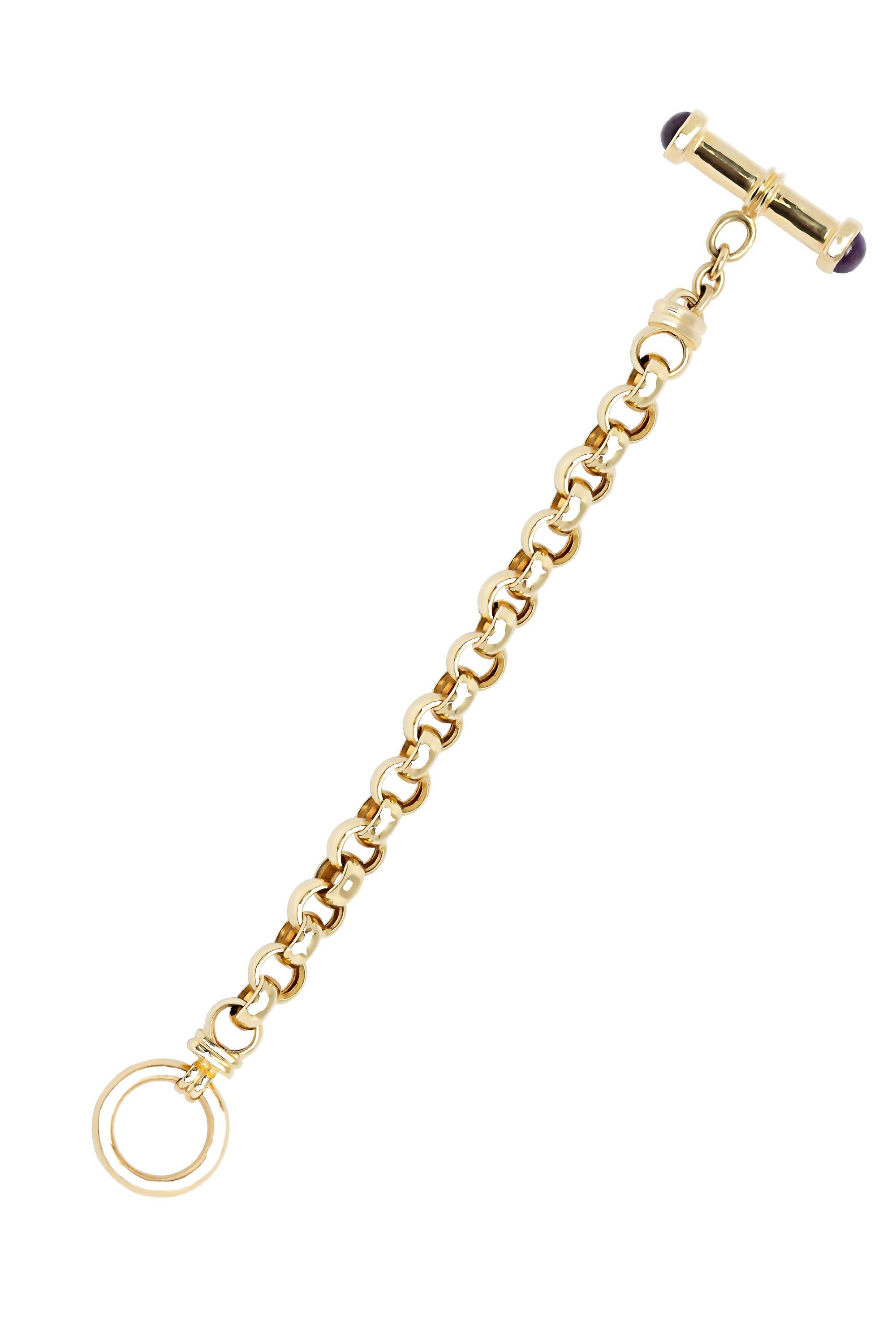 A true classic, this bracelet is composed of bold round links of highly polished 14-karat yellow gold. Completed by a toggle clasp smartly capped in cabochon amethyst ends. Measures 7 ¼ “ in length. Each link measures about 9mm width. The bracelet