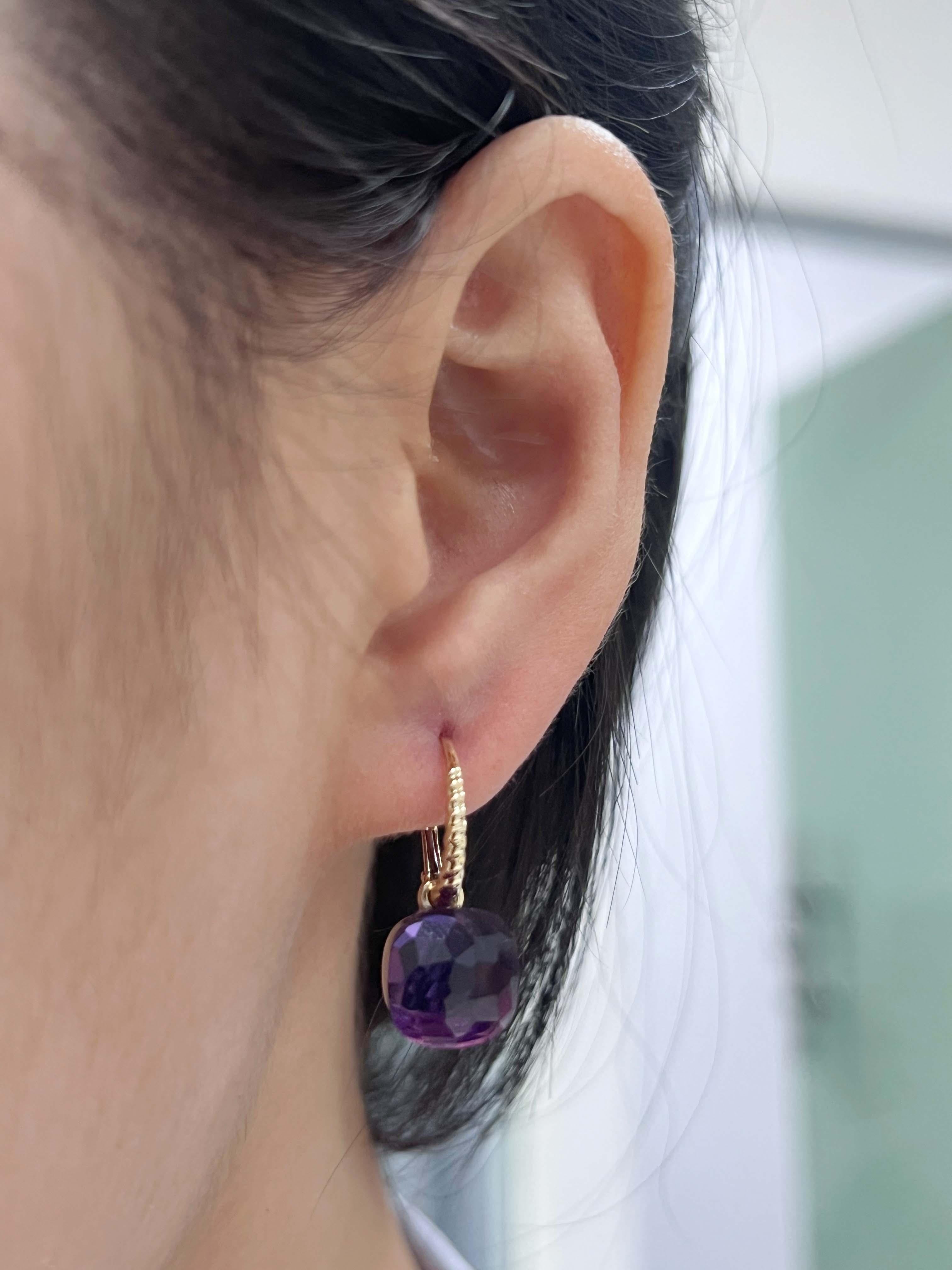Exuding elegance, these stunning earrings are crafted in 14 karat yellow gold, featuring two dazzling amethysts with a combined carat weight of 14.32. The rich purple hue of the amethysts, combined with the sleek yellow gold, creates a captivating