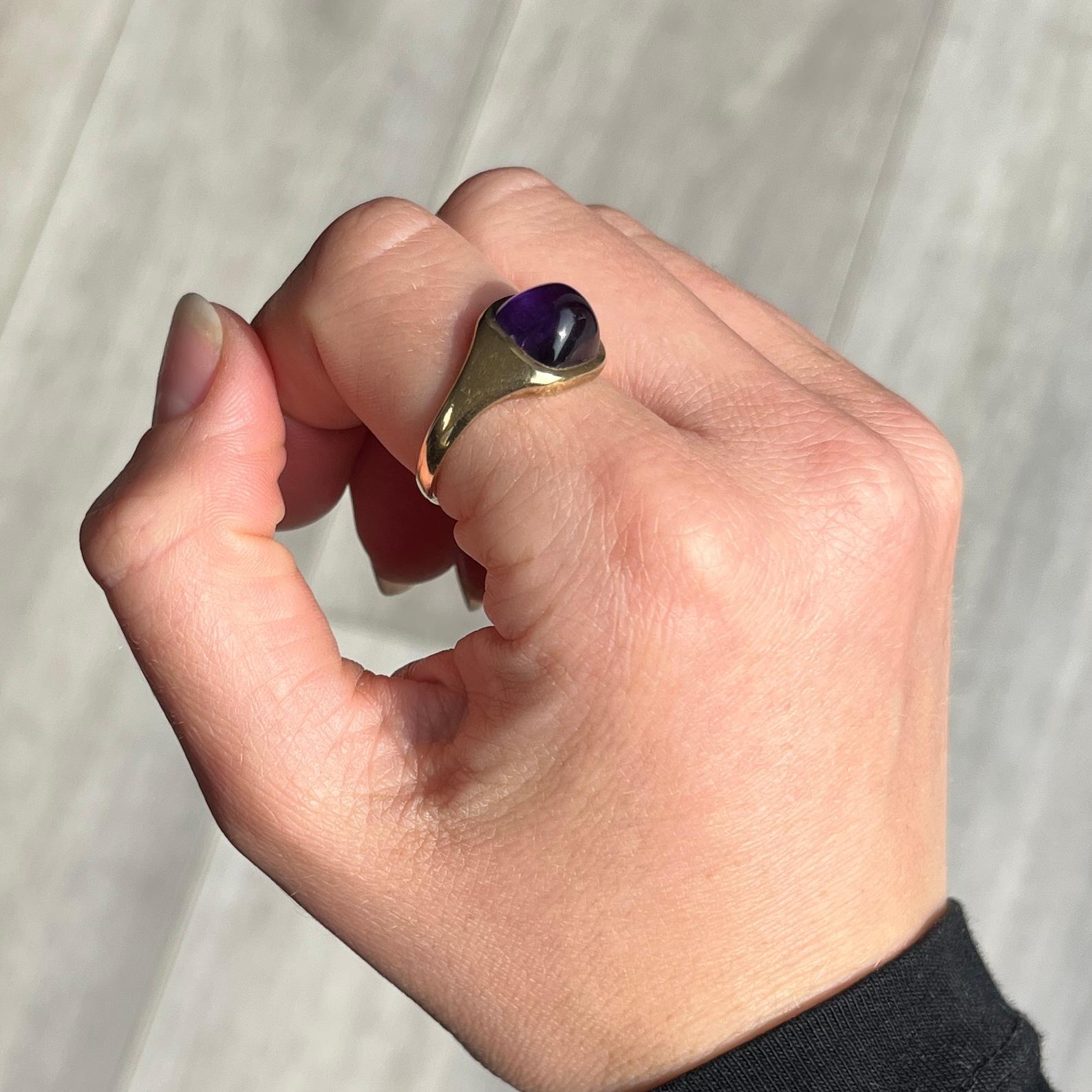 This glossy and bright purple amethyst stone is surrounded by a delicate frame of gold. Modelled in 9ct gold. Fully hallmarked London 1972.

Ring Size: R or 8 1/2 
Stone Diameter: 9mm 
Height off finger: 6.5mm

Weight: 4g