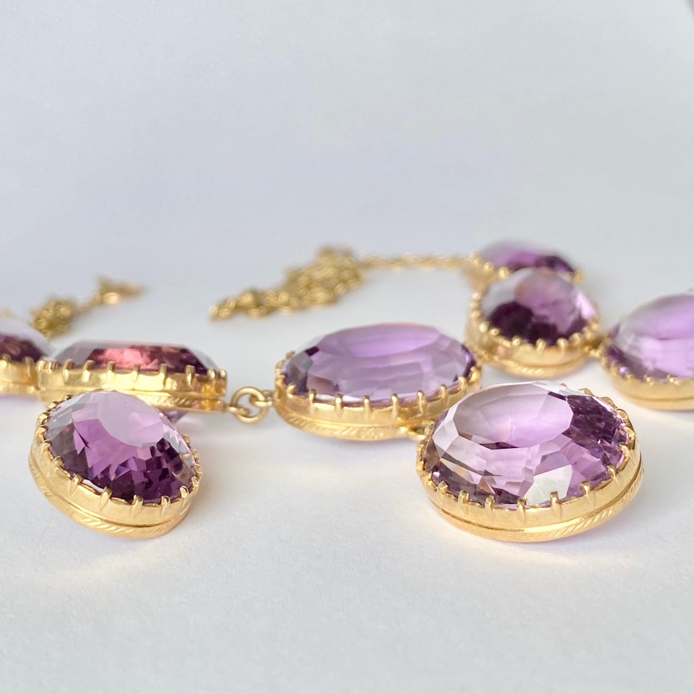 Sept superbes pierres d'améthyste violettes brillantes ornent ce collier. La chaîne en or 9ct est délicate par rapport aux pierres épaisses et se ferme à l'aide d'un fermoir à boulon.

Longueur : 47,5 cm
Dimensions des pierres : 16x12 -
