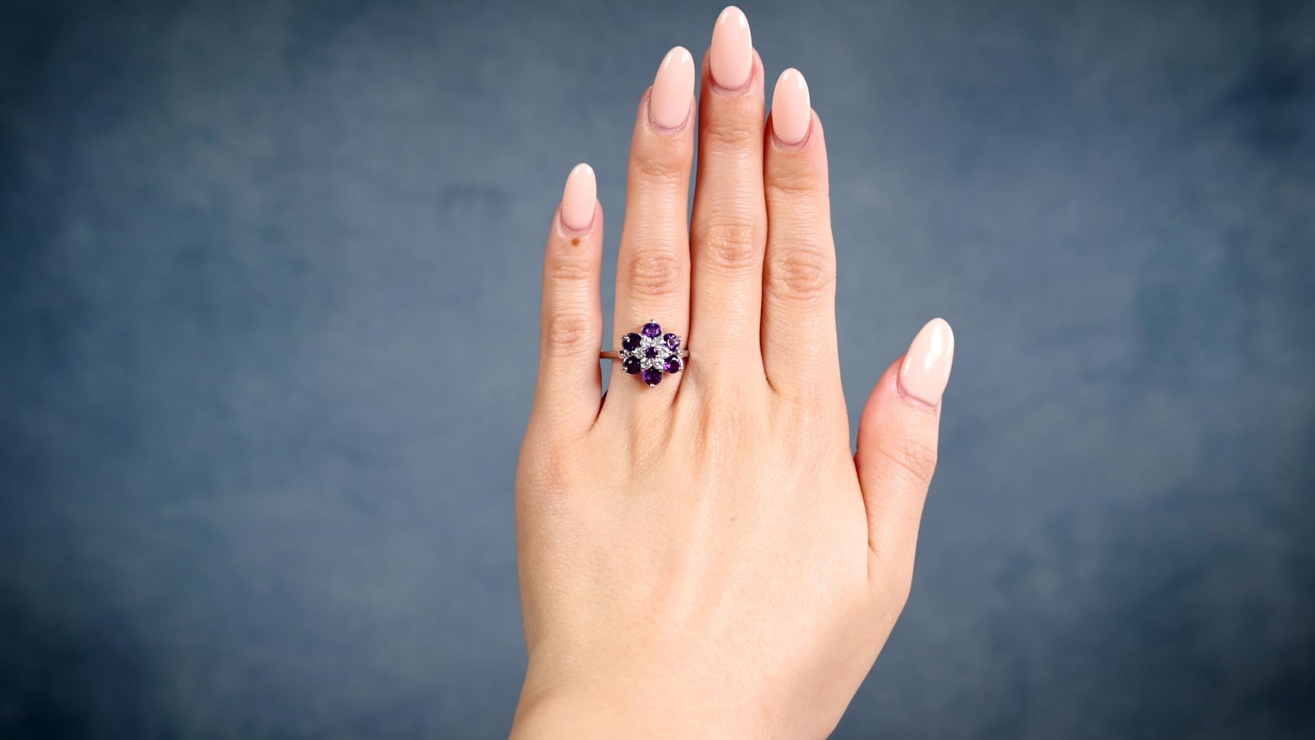 One Vintage Amethyst and Diamond 14k White Gold Flower Ring. Featuring seven round brilliant cut amethysts with a total weight of approximately 1.30 carats. Accented by six round brilliant cut diamonds with a total weight of approximately 0.25
