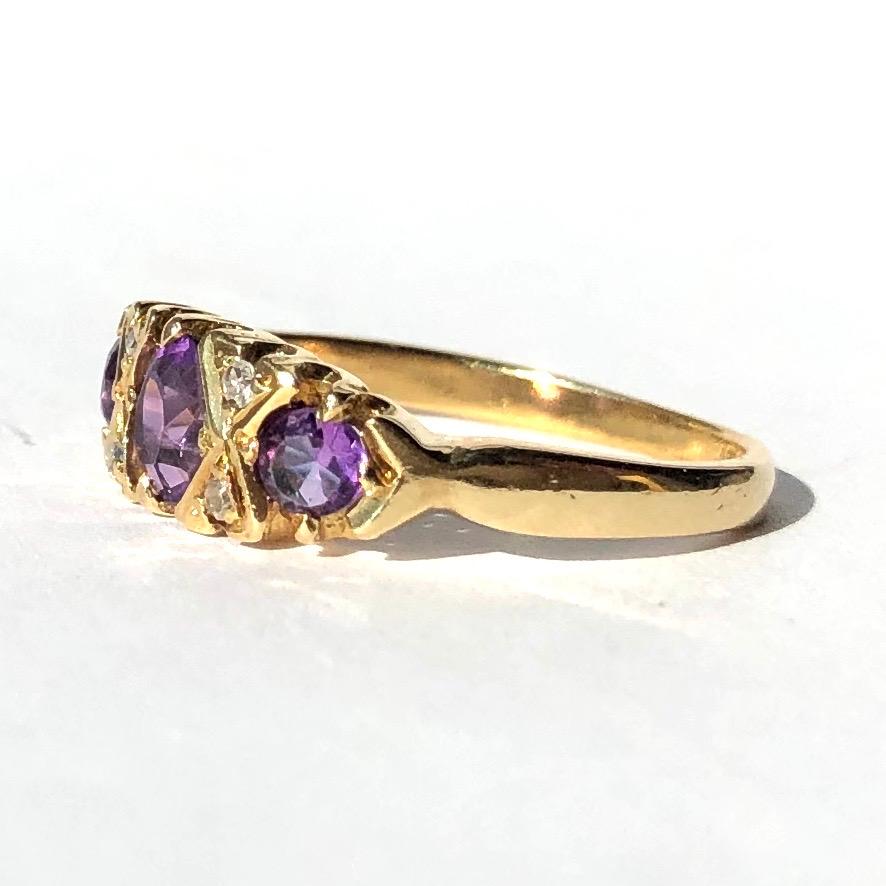 Set in the bright 18ct yellow gold are three bright purple amethyst stones which compliment each other beautifully. Either side of the 35pt central amethyst is a criss cross of gold and two bright shimmering diamonds sat within. 

Ring Size: K 1/2