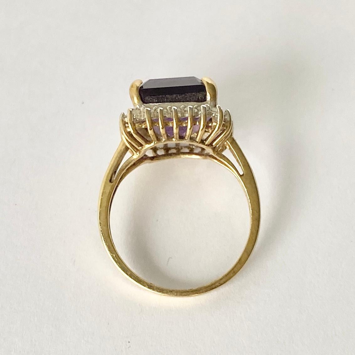 The gorgeous amethyst stone in this cluster is a bright purple colour which is complimented by the bright diamonds which surround it. The diamonds total approx 30pts. The ring is modelled in 9ct white gold.  

Ring Size: M or 6 1/4  
Cluster