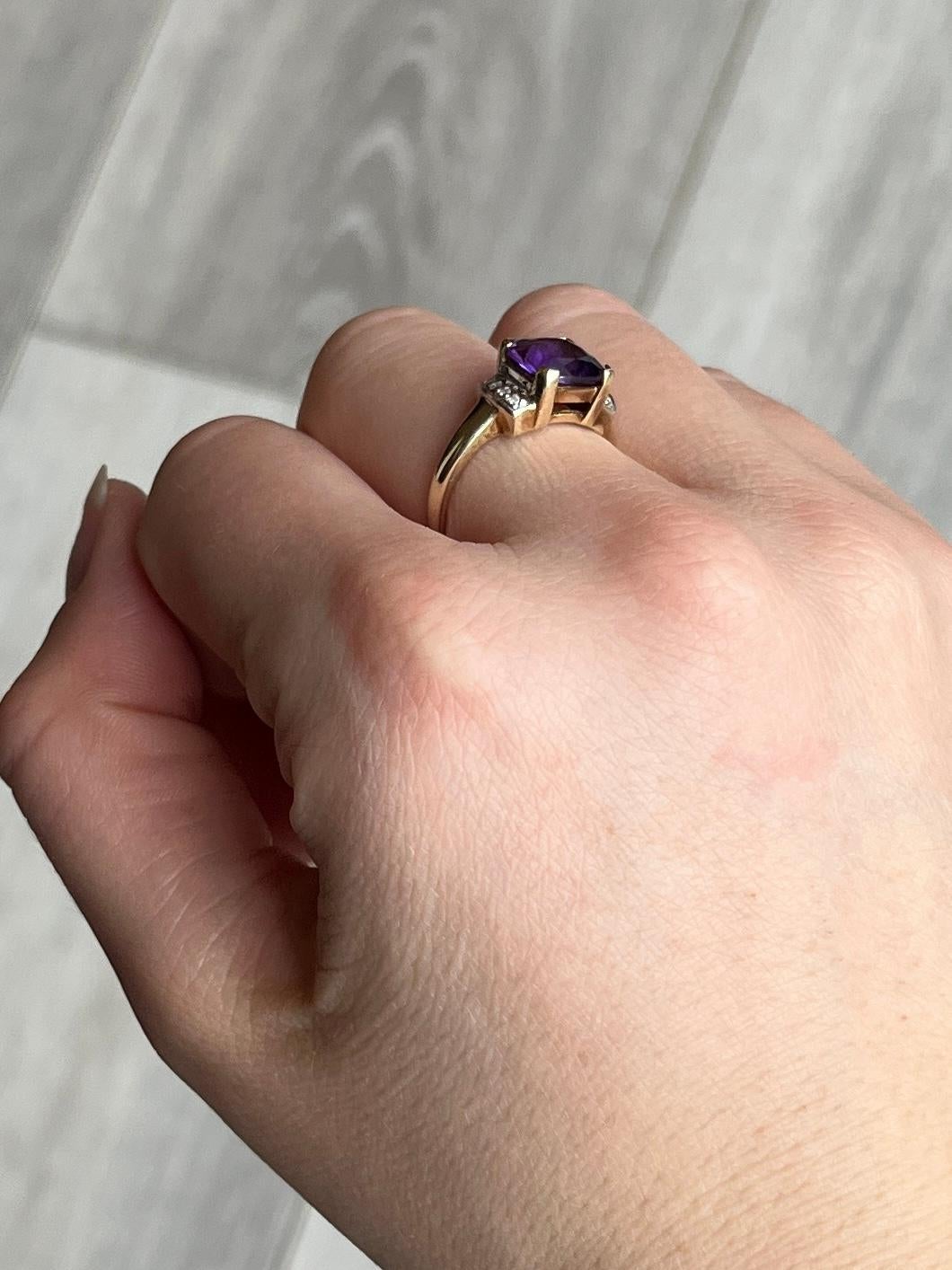 The amethyst stone in this ring is bright and a gorgeous colour. There are two rows of four diamonds that sit either side of the central stone. Diamond total 8pts. Modelled in 9carat gold. Amethyst dimensions 8x8mm.

Ring Size: L 1/2 or 6 
Height